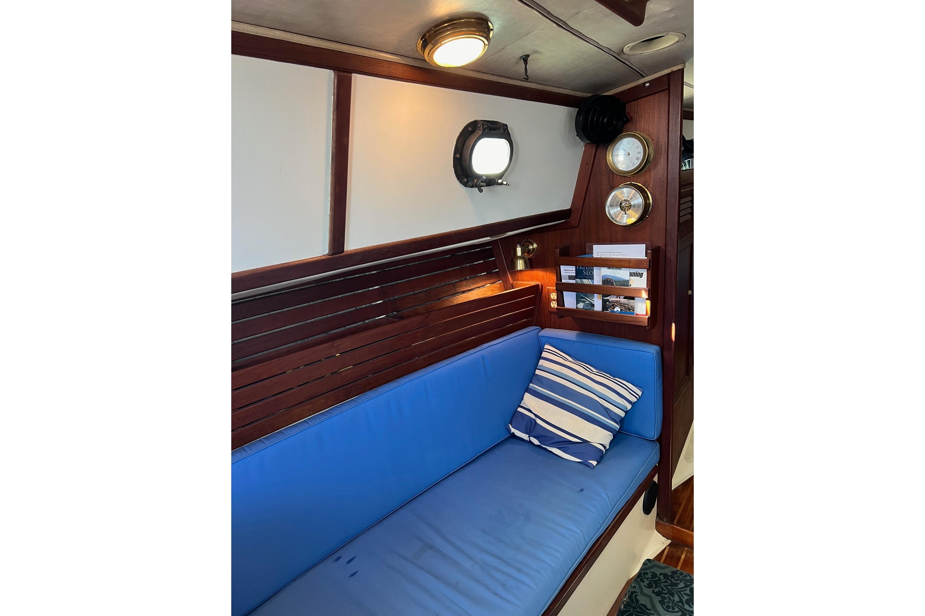 Interior of 1982 Pacific Seacraft 37 sailboat with blue cushioned seating and nautical decor.