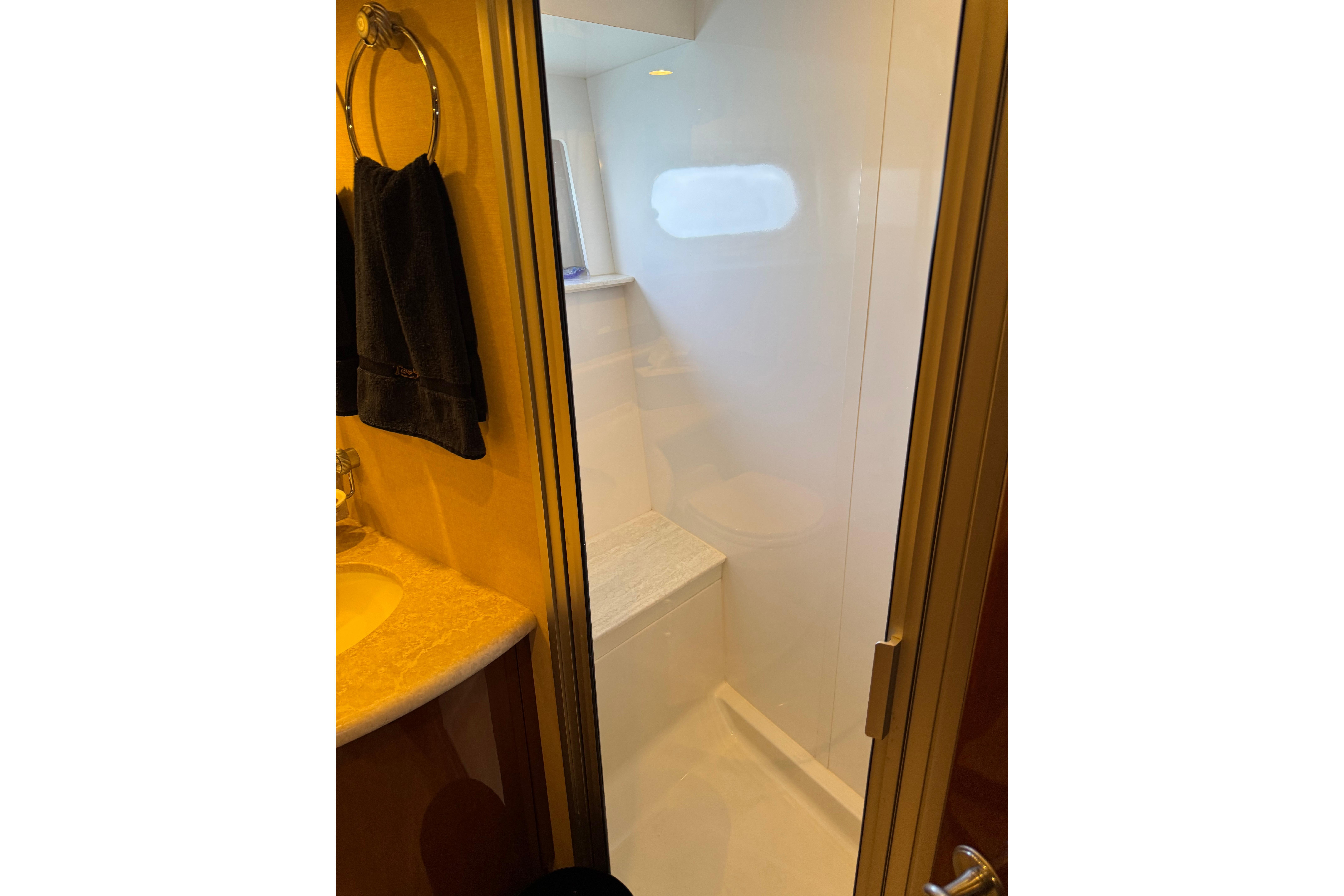 Shower area in 2006 Marquis 59 yacht bathroom with towel and sink.