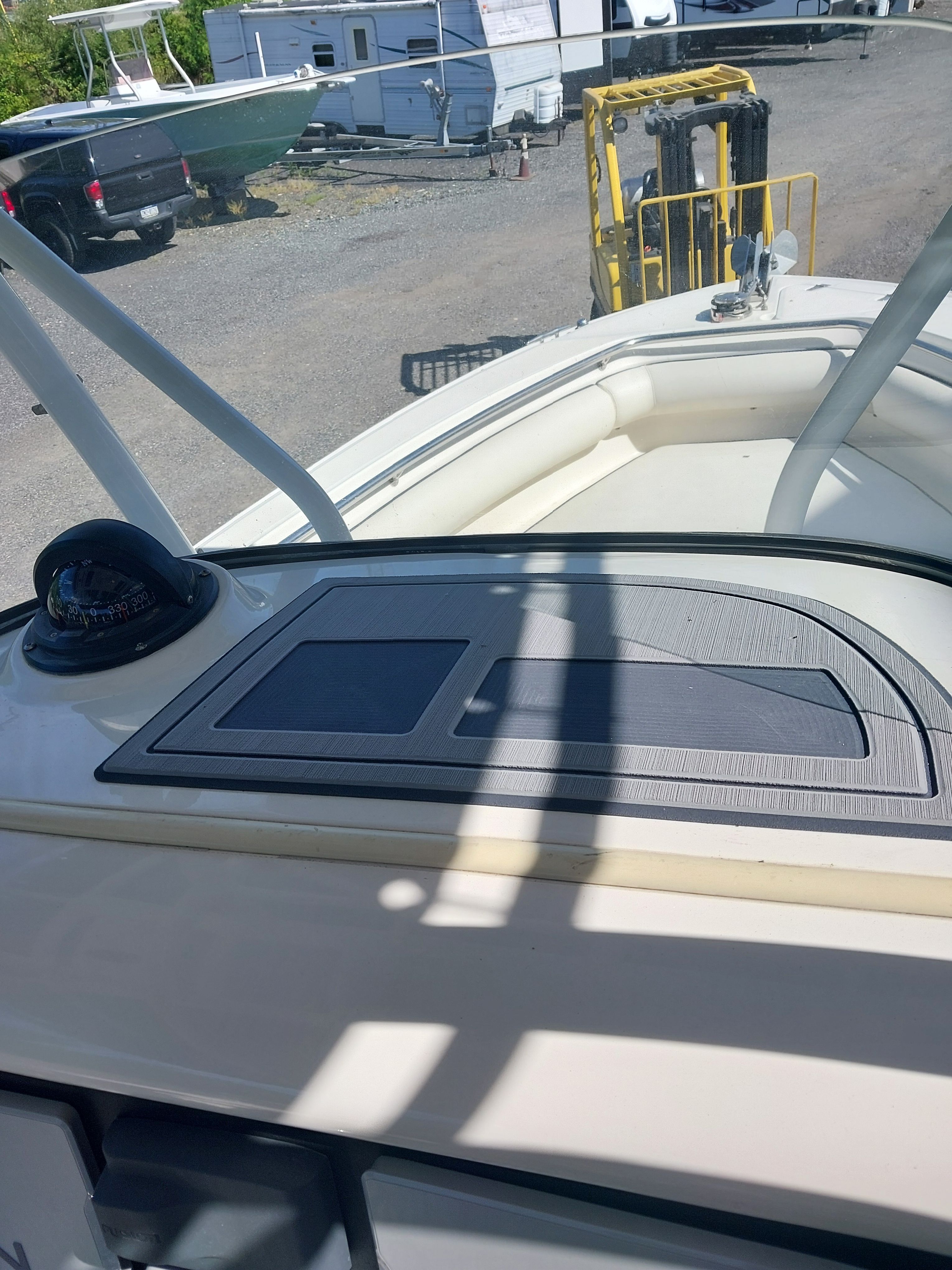 The image shows the deck of a 2005 Boston Whaler 240 Outrage. It is situated in a parking area.