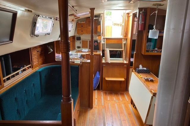 Interior of 1988 Bayfield 36 Cutter sailboat with wooden finishes and cozy seating area.