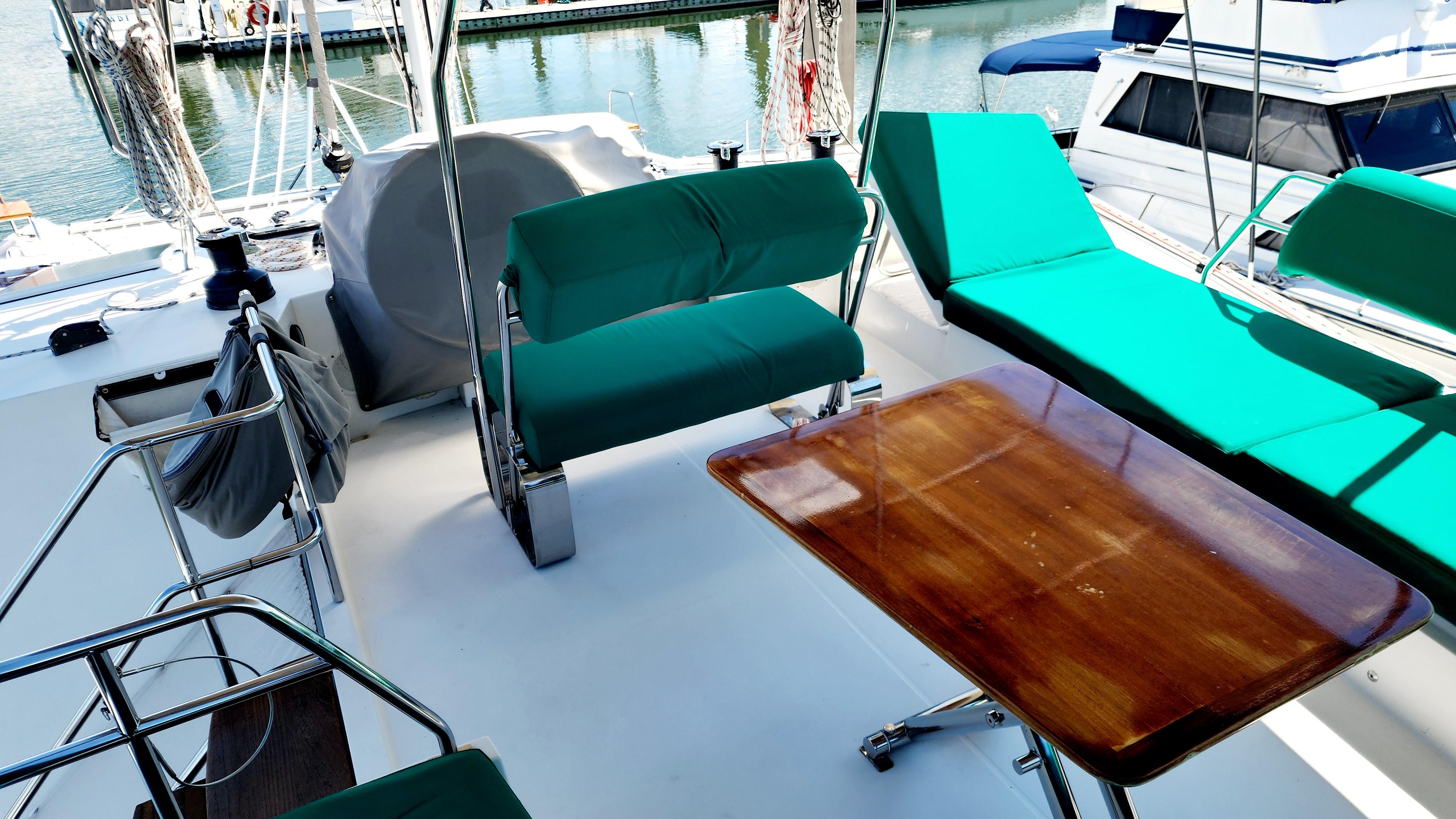 Nautitech 46 Fly 2017 yacht deck with green seating and wooden table.