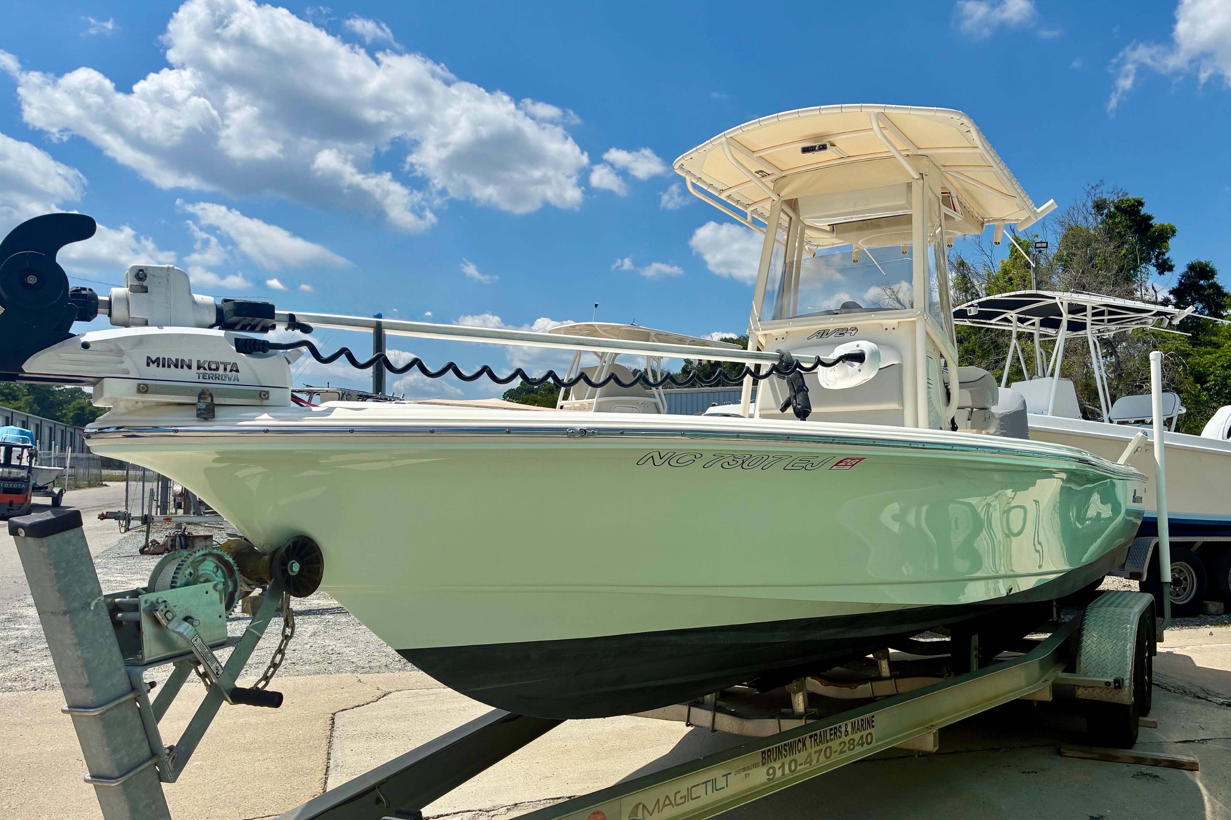 2018 Avenger AV24 boat on trailer under blue sky with clouds.