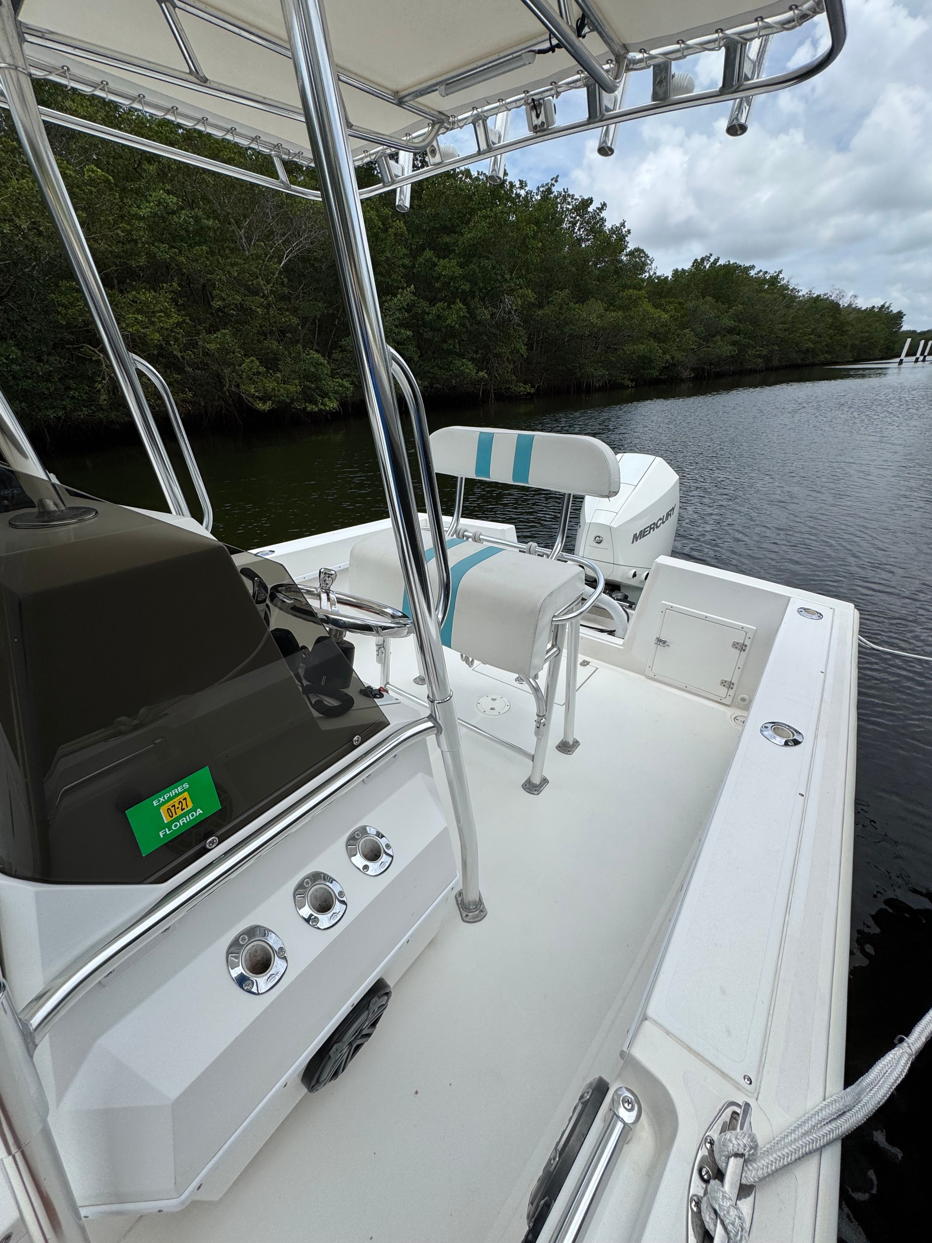 The image shows a 2004 Contender 21 boat on calm water.