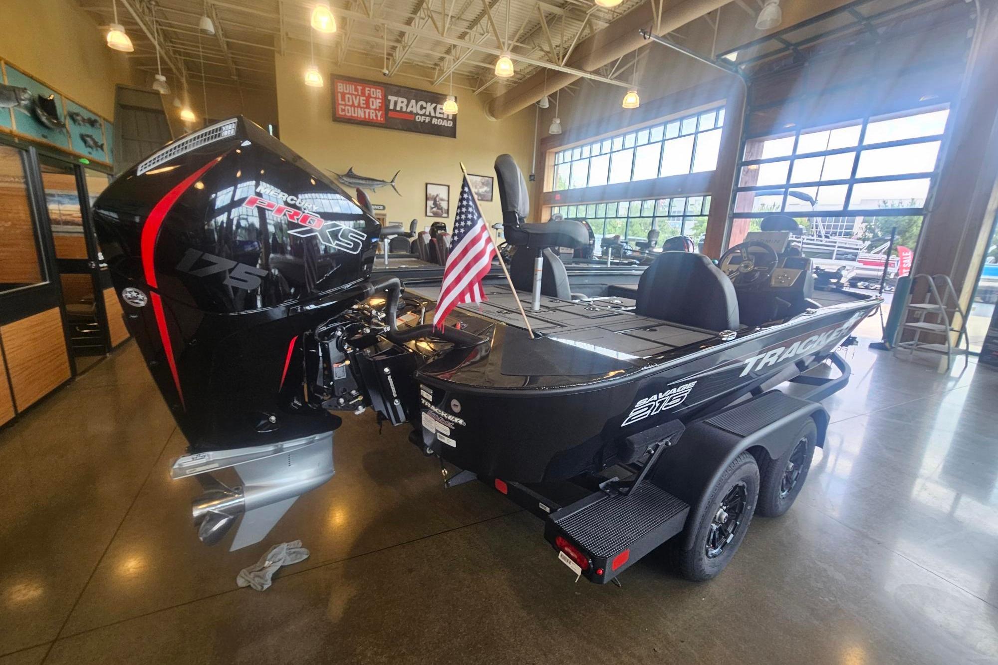 2026 Tracker Savage 215 boat with Mercury Pro XS engine displayed indoors.