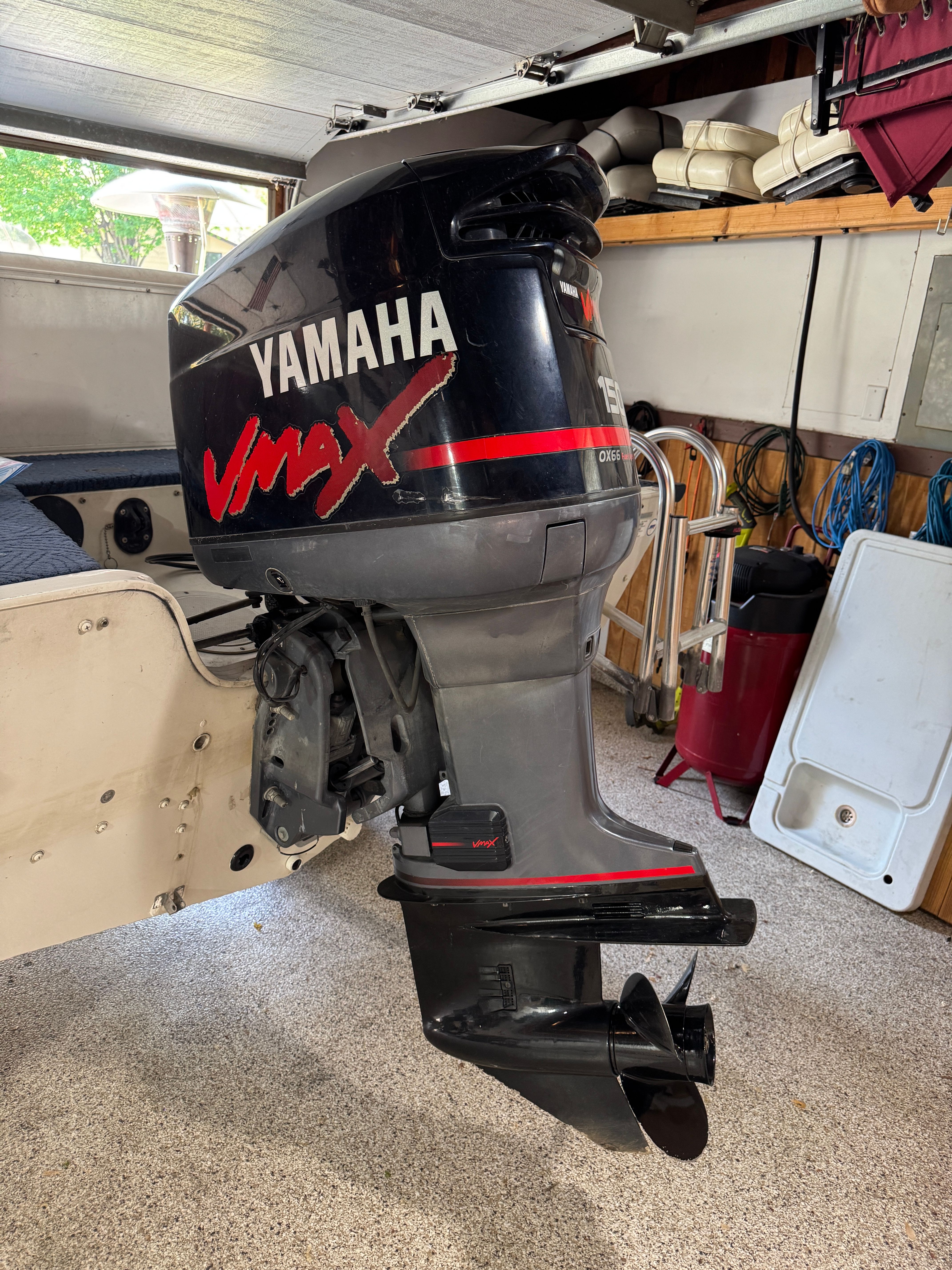 A Yamaha VMAX outboard motor is mounted on a boat inside a garage.