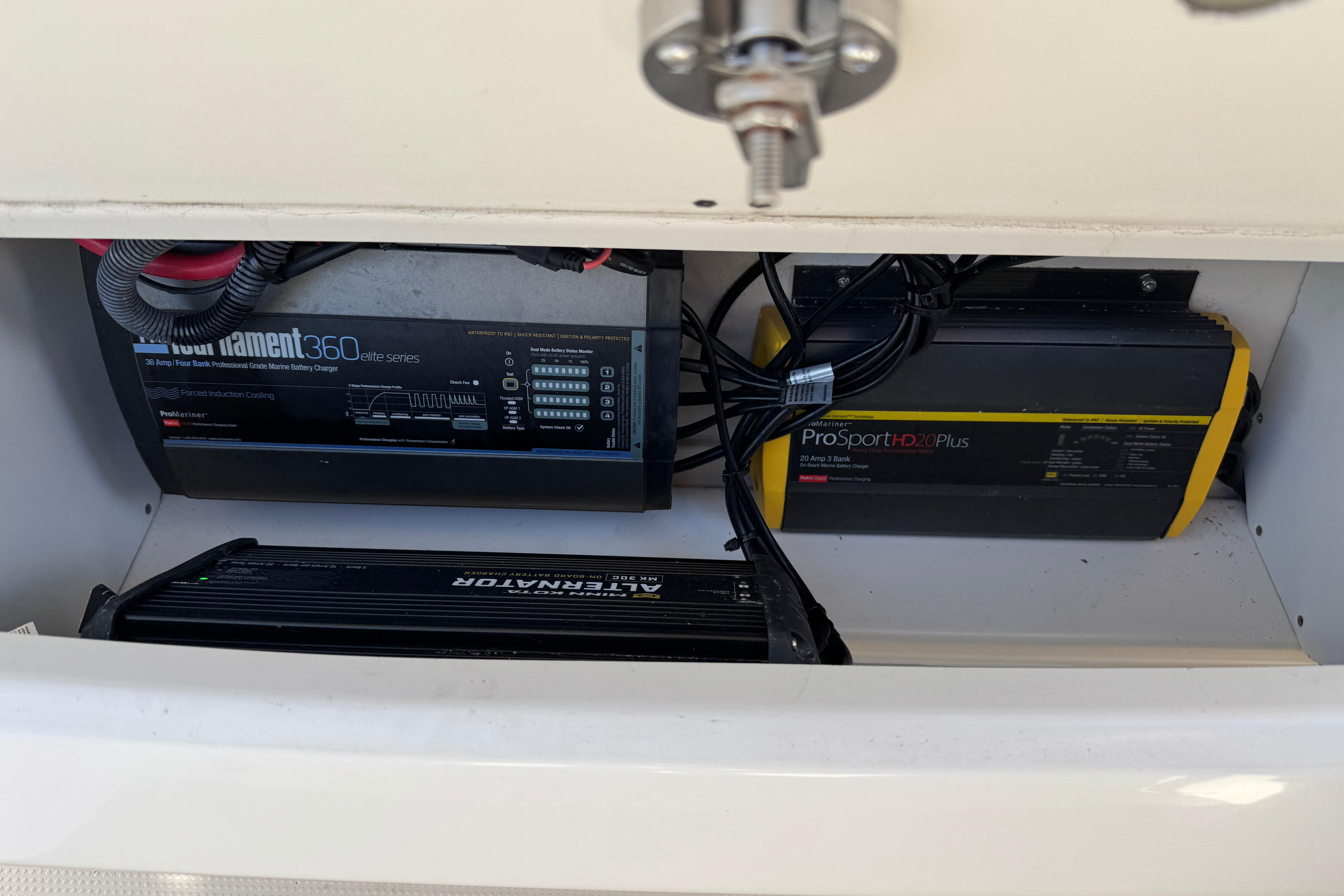 Marine battery chargers in a 2022 Sailfish 242 CC boat compartment.