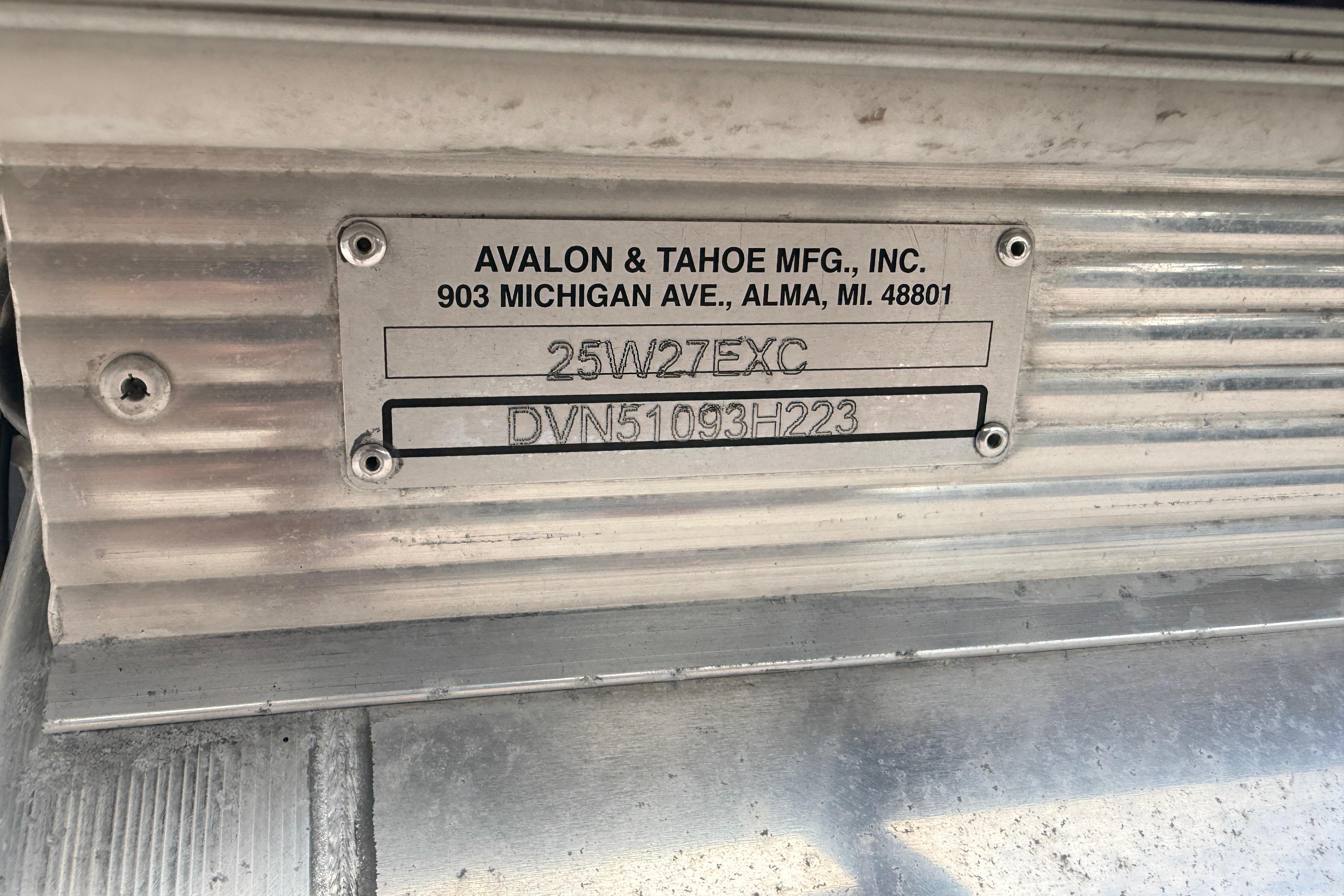 Metal identification plate on 2023 Avalon Excalibur 2585 Windshield Elite boat, showcasing manufacturer details.