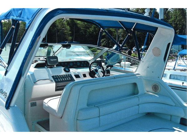 1996 Sea Ray 300 Sundancer boat interior with blue canopy and steering console.