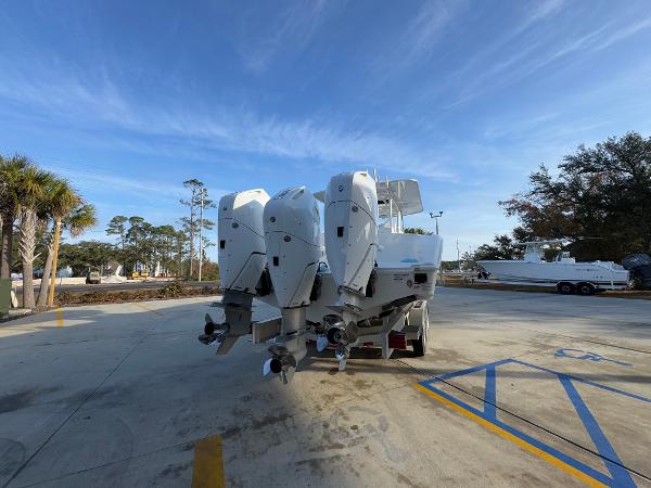 2025 Yellowfin 39 Offshore boat with triple outboard engines in a parking area.