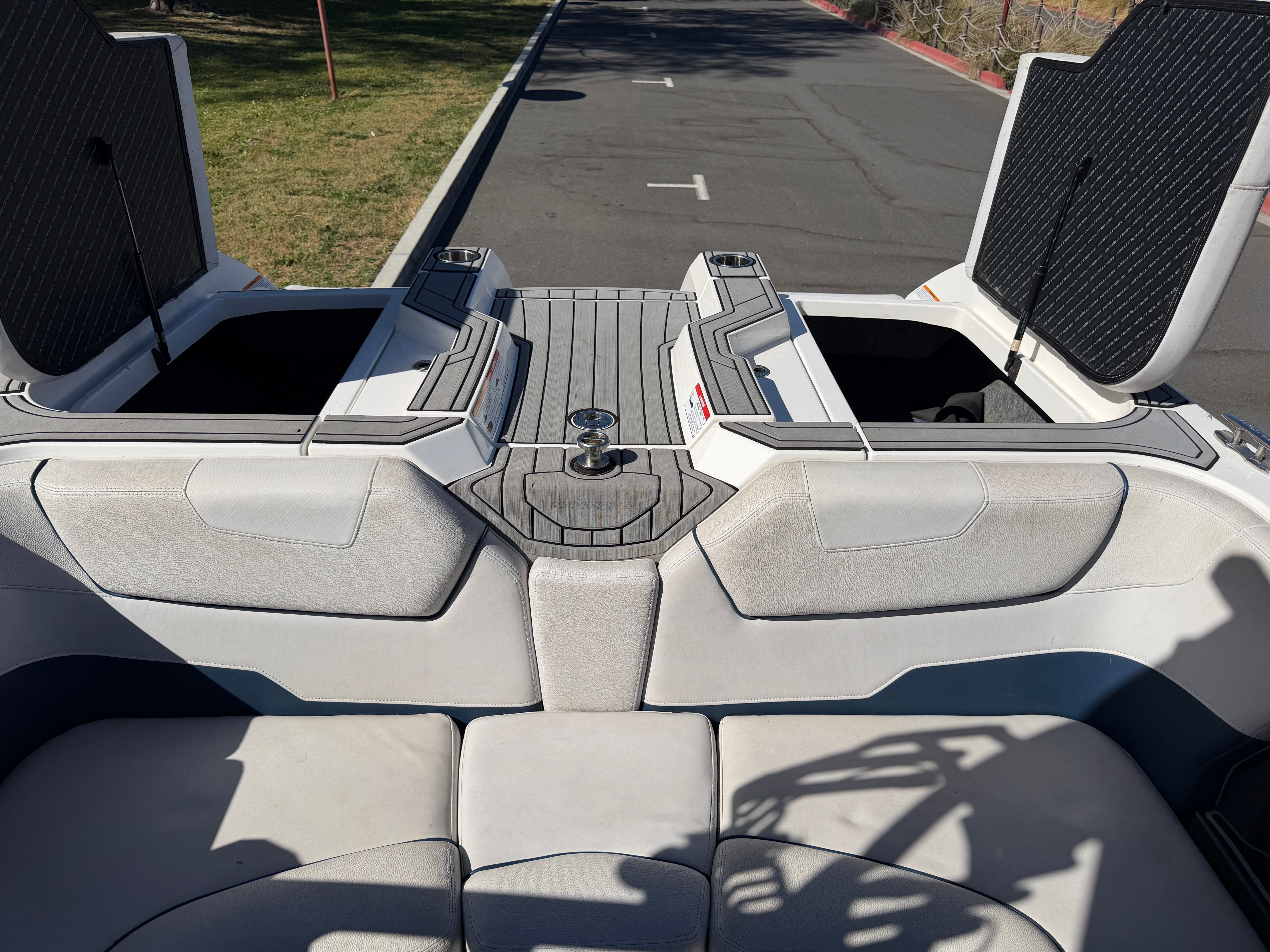The image shows the rear of a 2018 Nautique Super Air Nautique GS22 with open storage compartments.