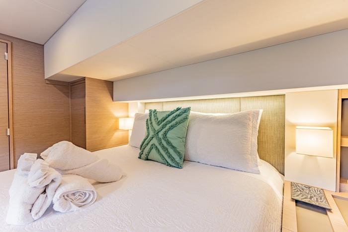 Luxurious bedroom interior of 2023 Fountaine Pajot Samana 59 yacht with elegant bedding.