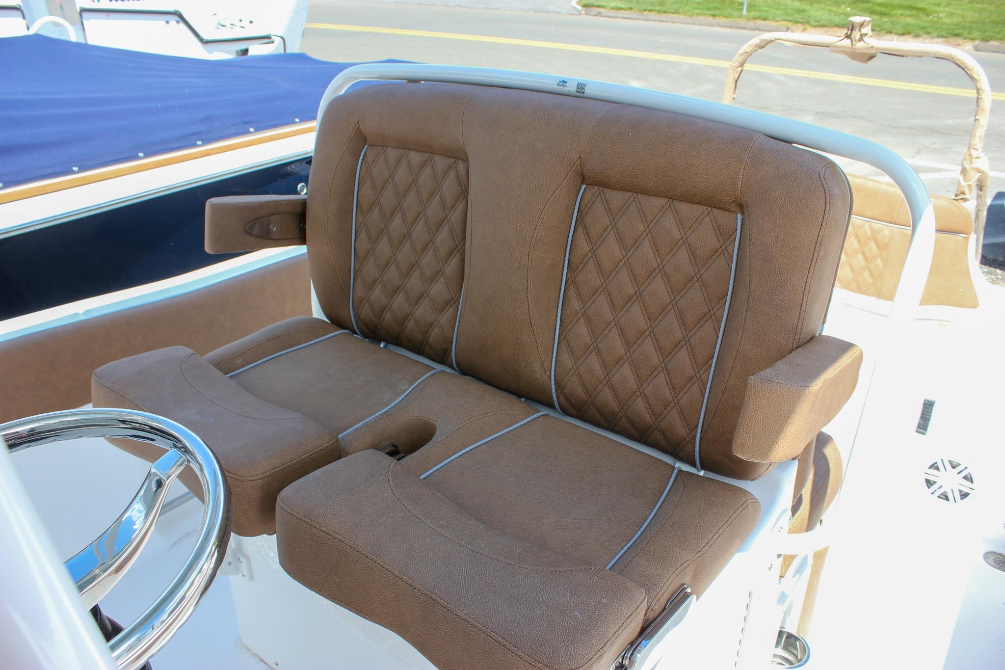 Brown leather seating on 2027 Sea Hunt Ultra 234 boat, featuring diamond stitching and armrests.