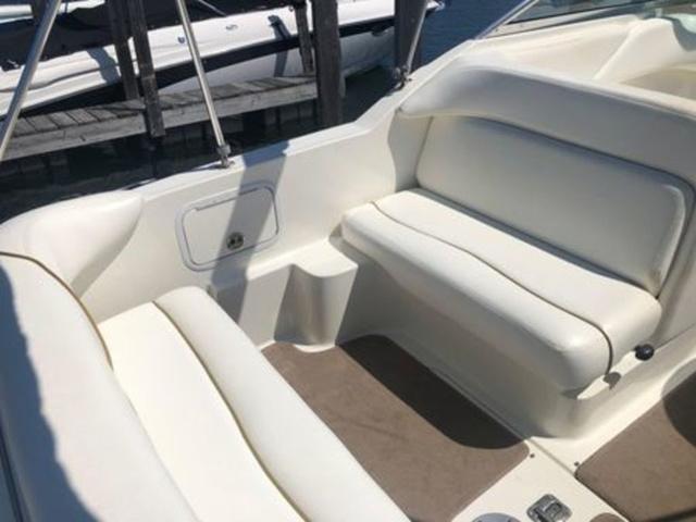 2003 Sea Ray 260 Sundancer boat interior with white seating and beige flooring.