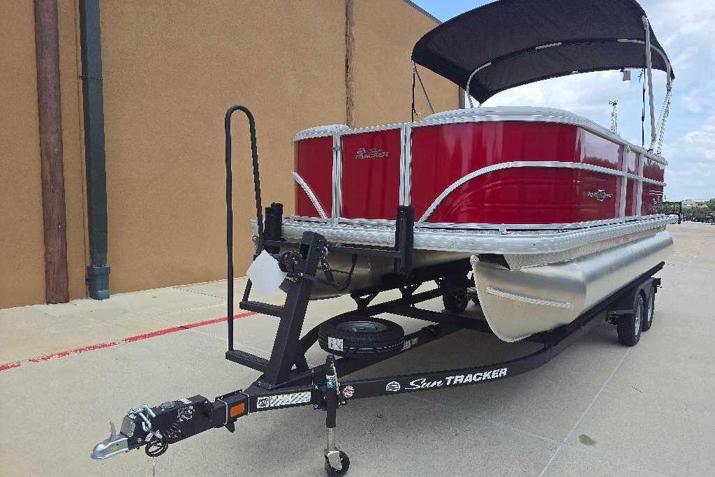 2026 Sun Tracker Party Barge 20 DLX pontoon boat on trailer, red exterior, black canopy.