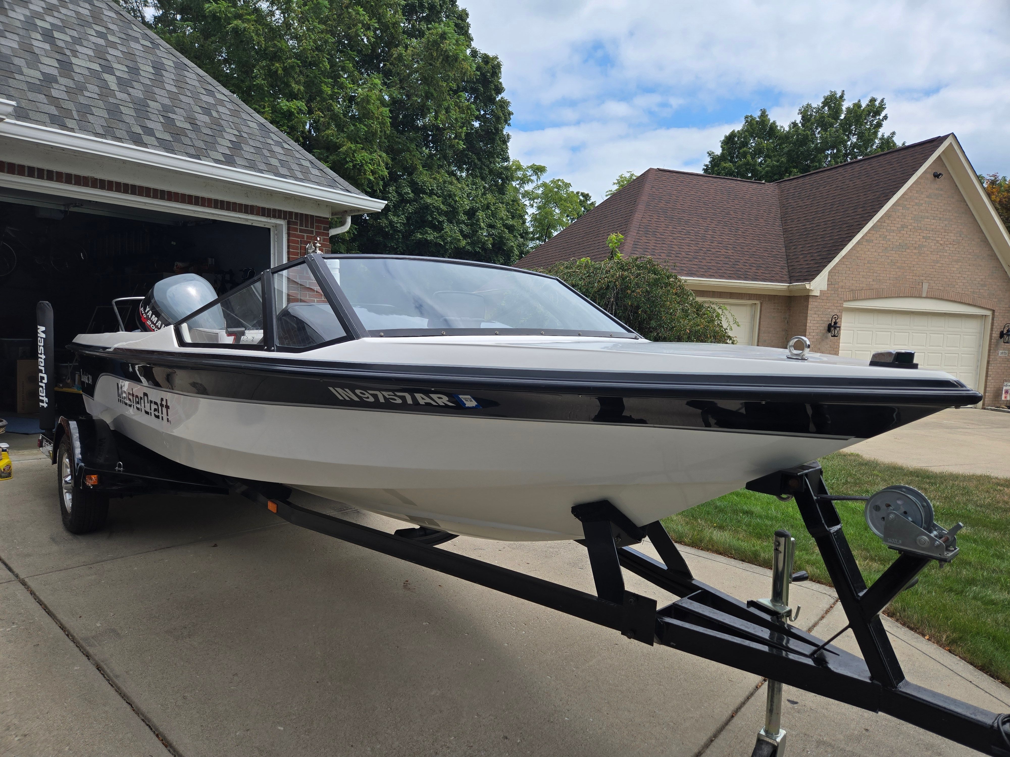 1991 MasterCraft Barefoot 200 boat on trailer in driveway.