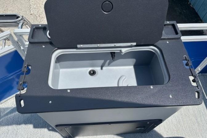 Open storage compartment on 2026 Sun Tracker Fishin' Barge 20 DLX boat.