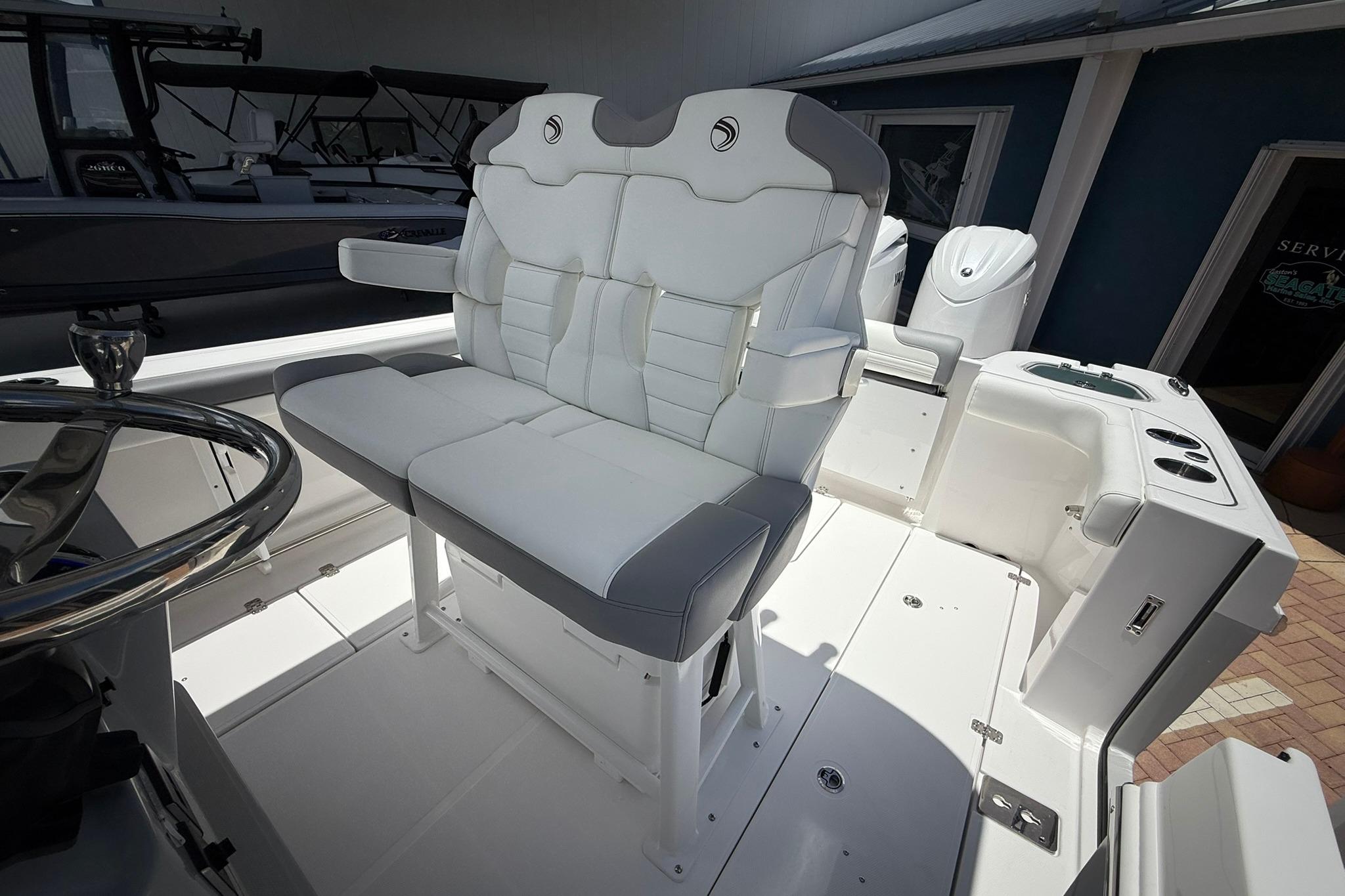 2026 Edgewater 250CC boat interior with white cushioned seating and steering wheel.