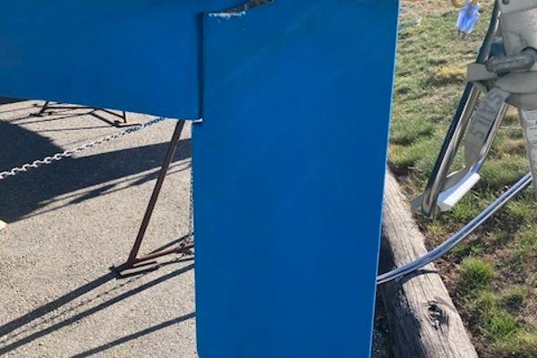 Blue keel of a 1989 Catalina 30 sailboat on a stand outdoors.