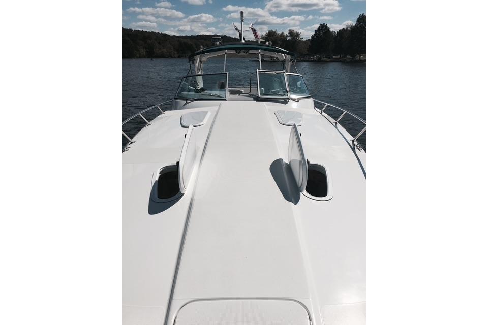 1999 Formula 400 Super Sport boat on a lake under a partly cloudy sky.