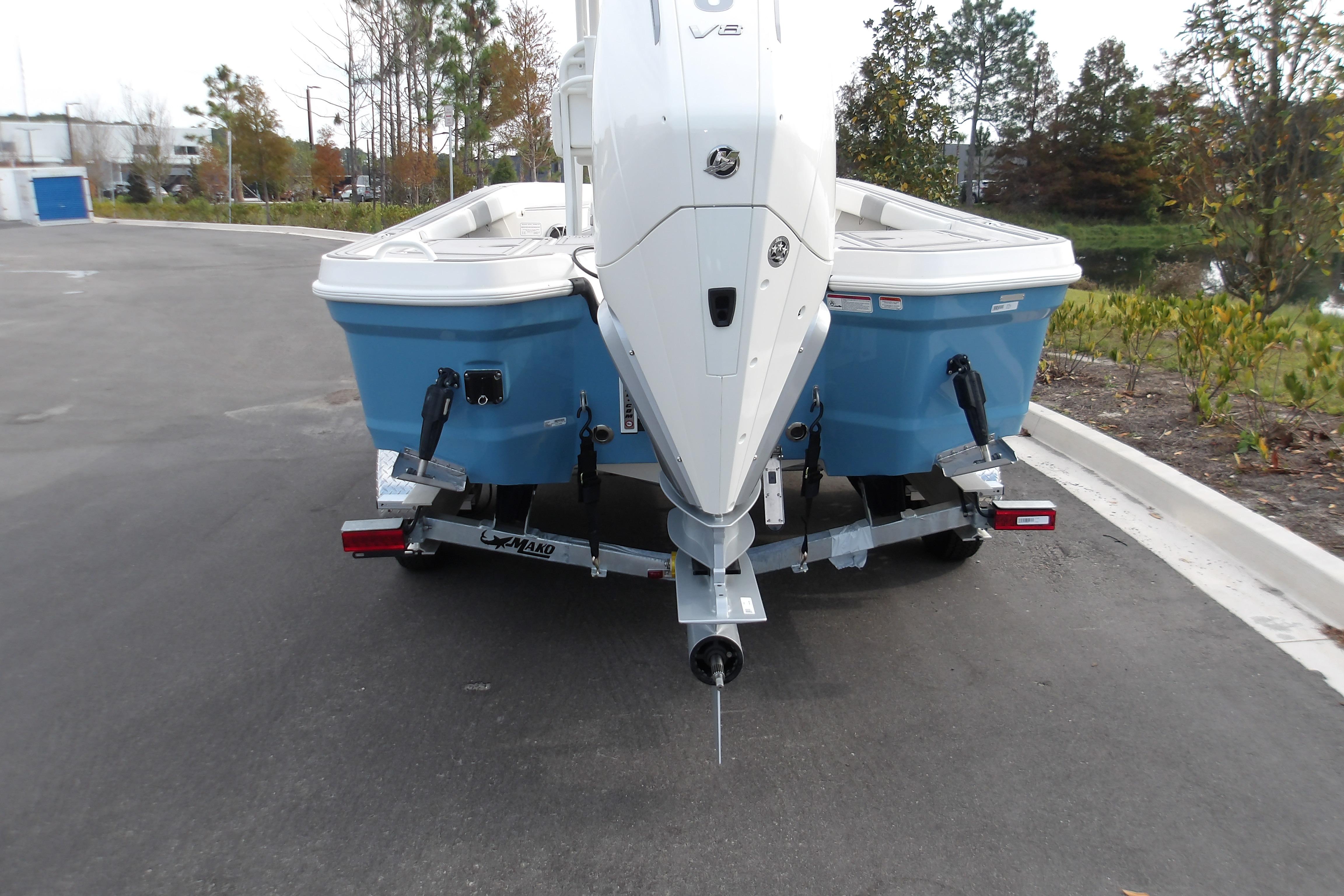 2026 Mako 24 APEX boat on trailer, rear view, parked outdoors.