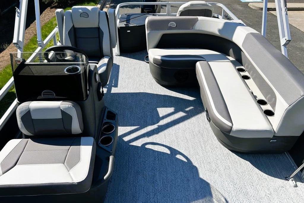 2026 Sun Tracker Bass Buggy 18 DLX pontoon boat interior with gray seating and cup holders.