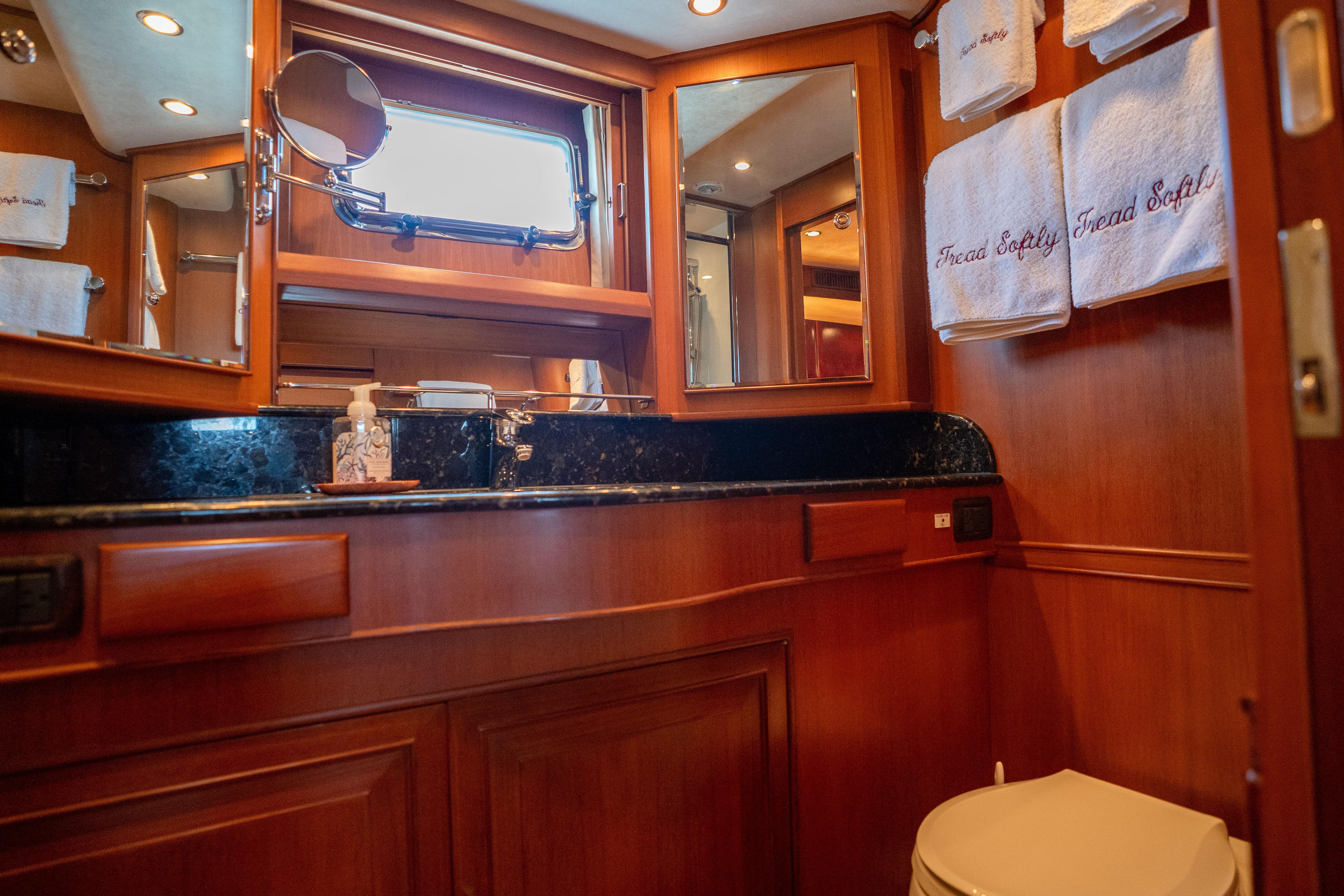 Luxurious 2006 Fleming 75 yacht bathroom with wood paneling and elegant fixtures.