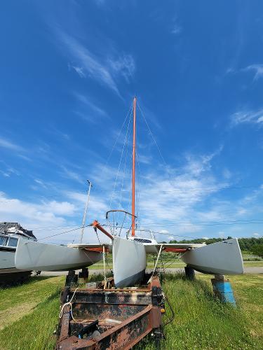 1985 Crowther Buccaneer catamaran on trailer under clear blue sky.