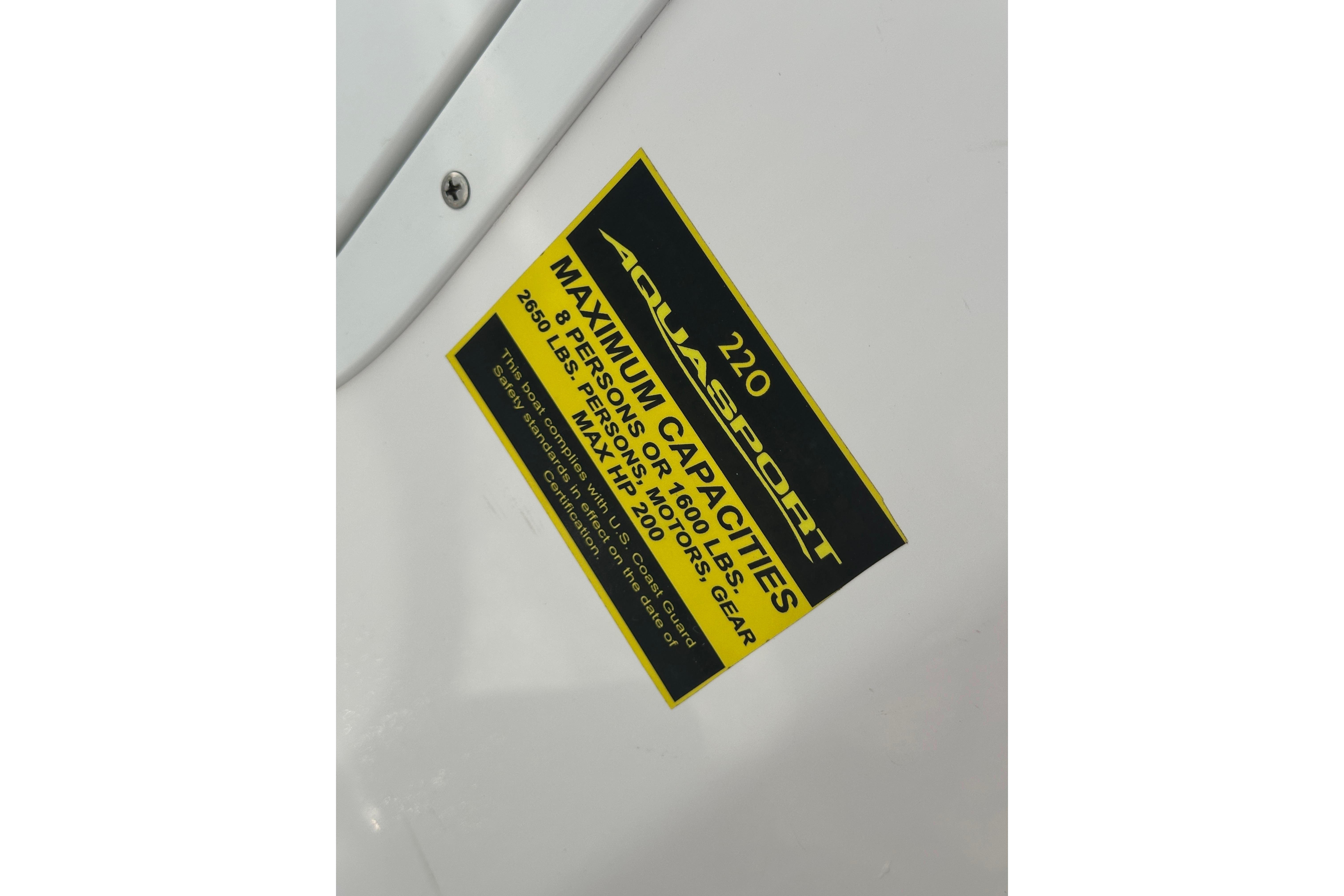 2024 Aquasport 2200 Dual Console capacity label detailing maximum weight and passenger limits.