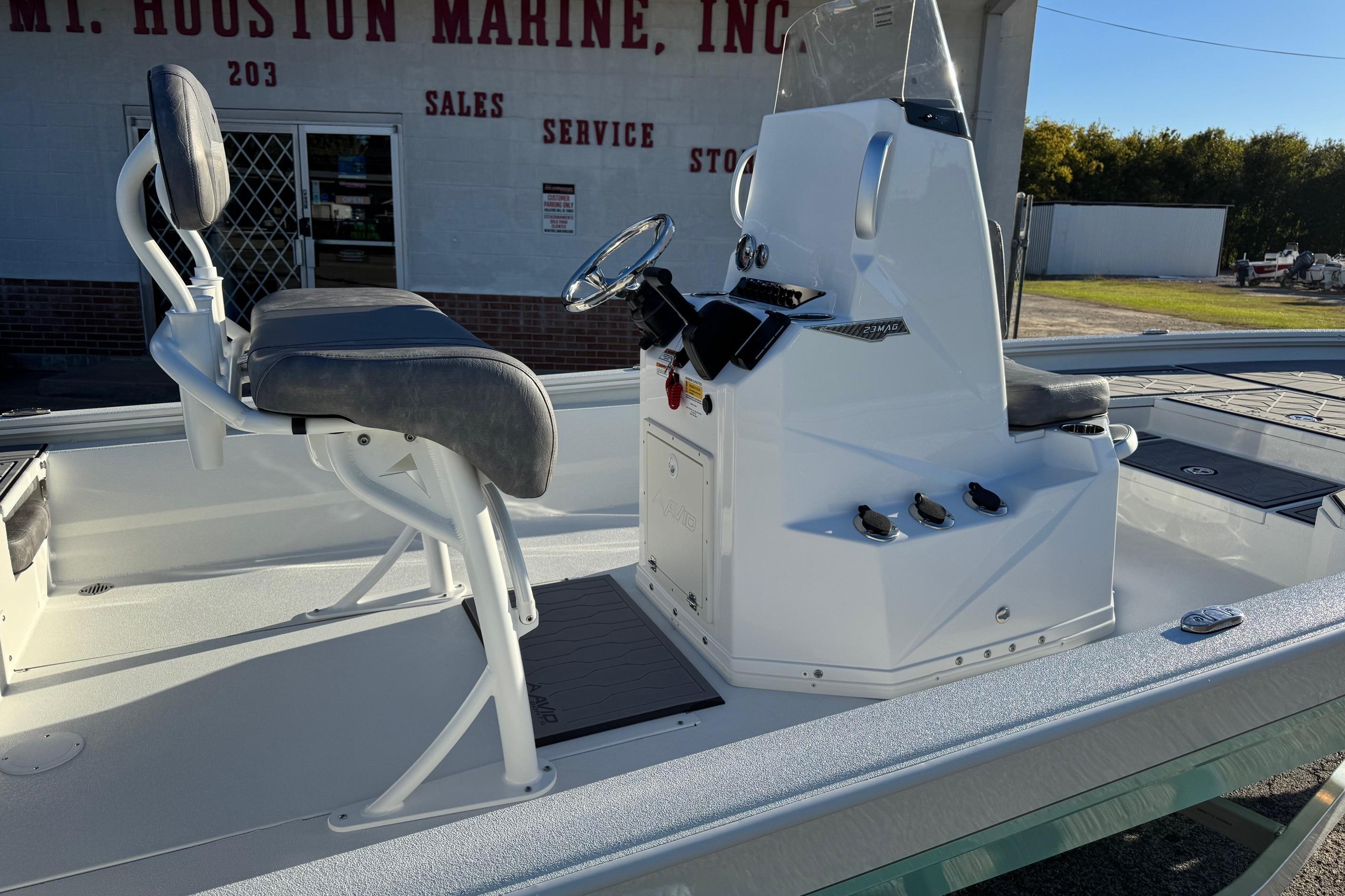 Avid 23 Mag 2025 boat interior with steering console and seating, outside marine store.