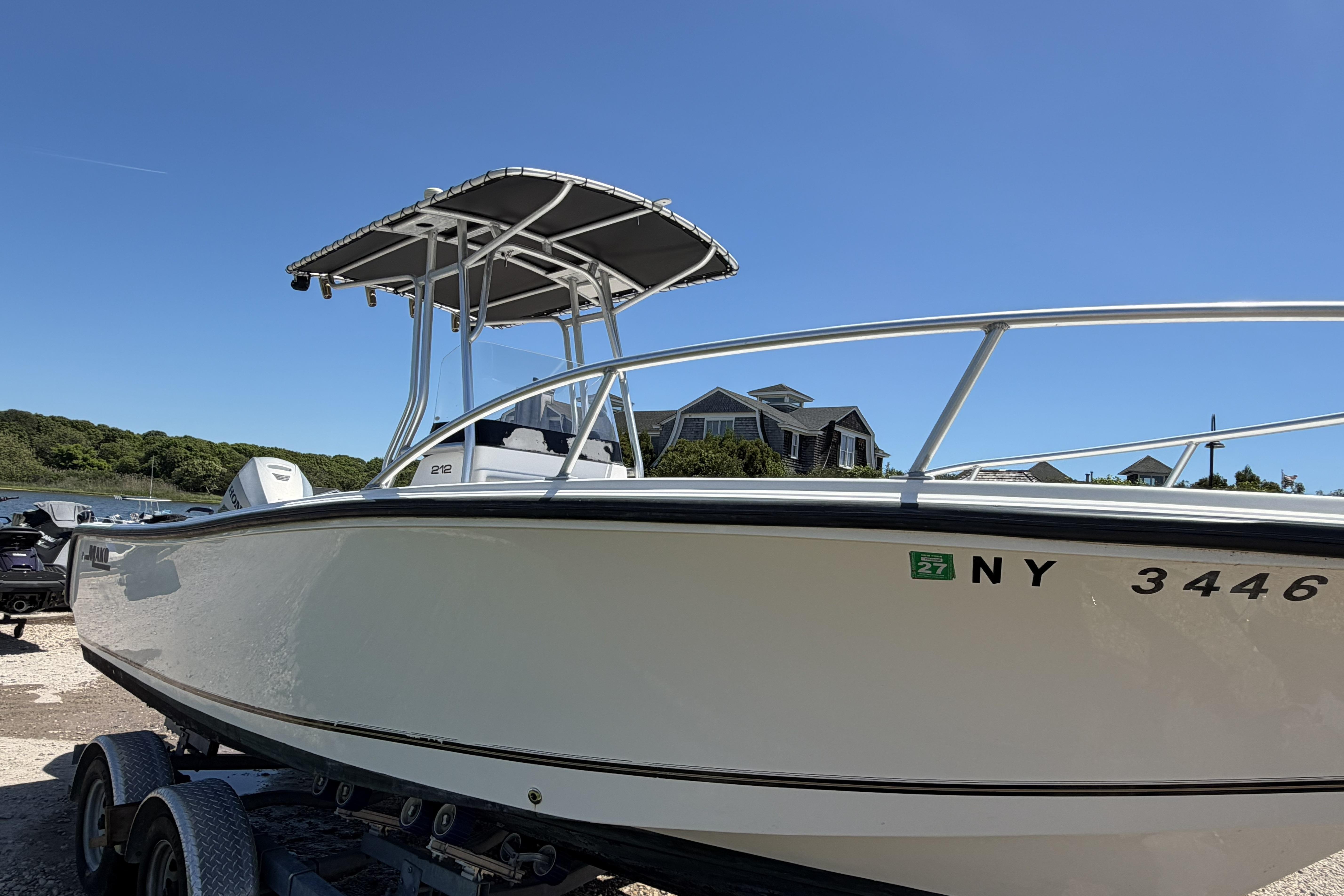 2006 Mako 212 Center Console boat on trailer, sunny day, residential background.