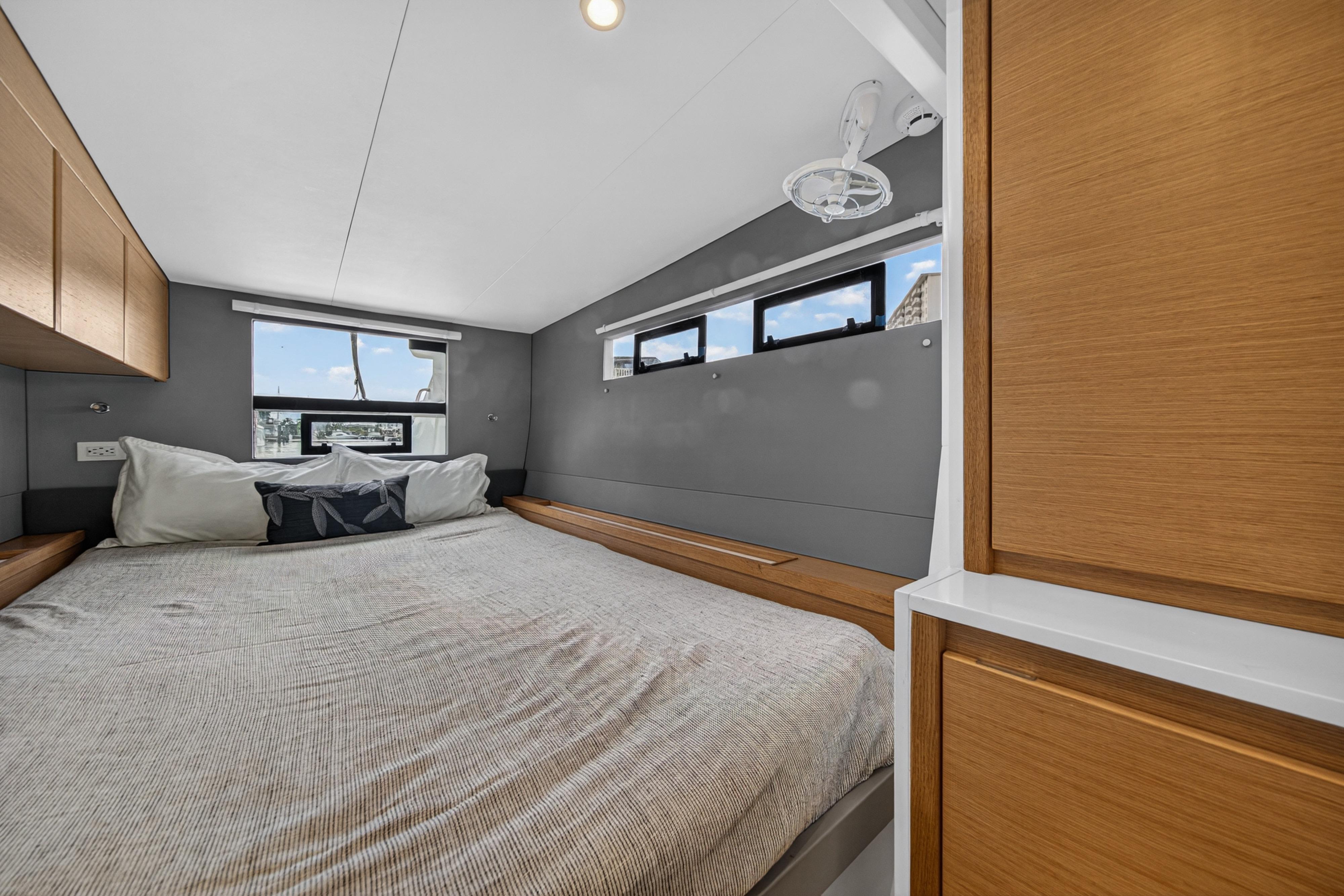 Modern bedroom interior in Balance 482 yacht, featuring cozy bed and wooden cabinetry, 2023 model.