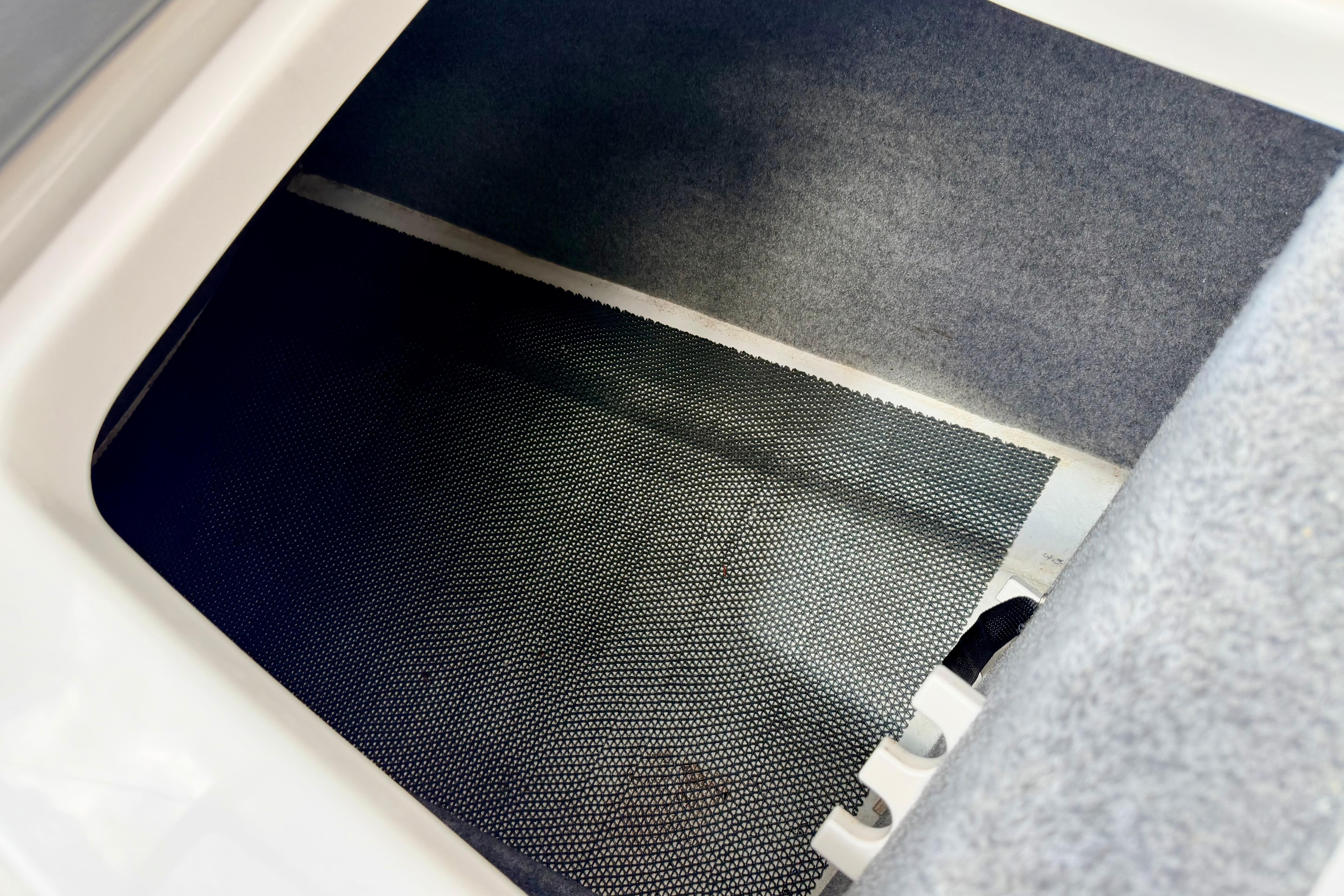 Storage compartment in 2015 Chaparral Sunesta 264 boat, featuring carpeted interior.