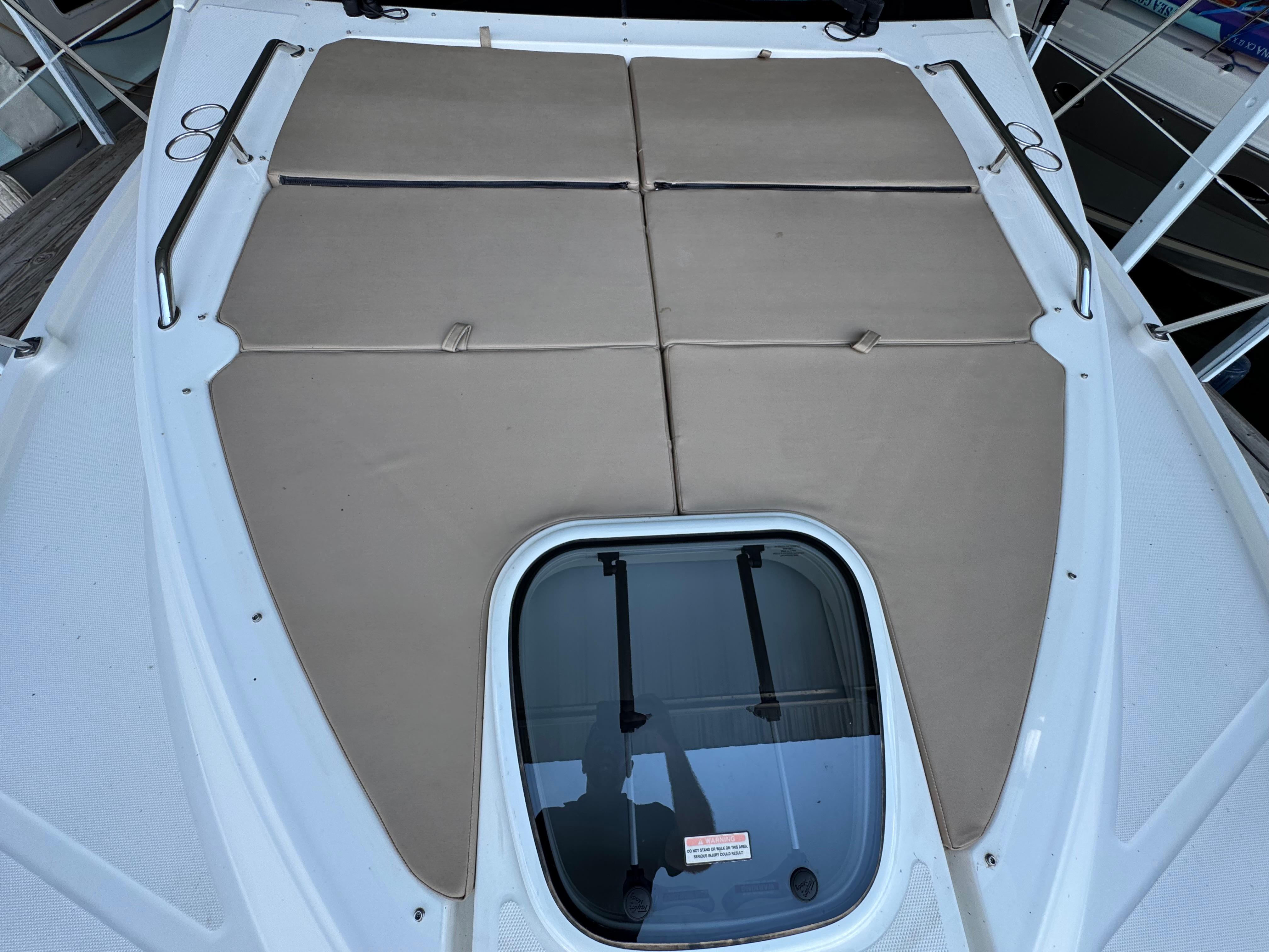 2017 Sea Ray Sundancer 400 deck with cushioned sunbathing area and hatch window.