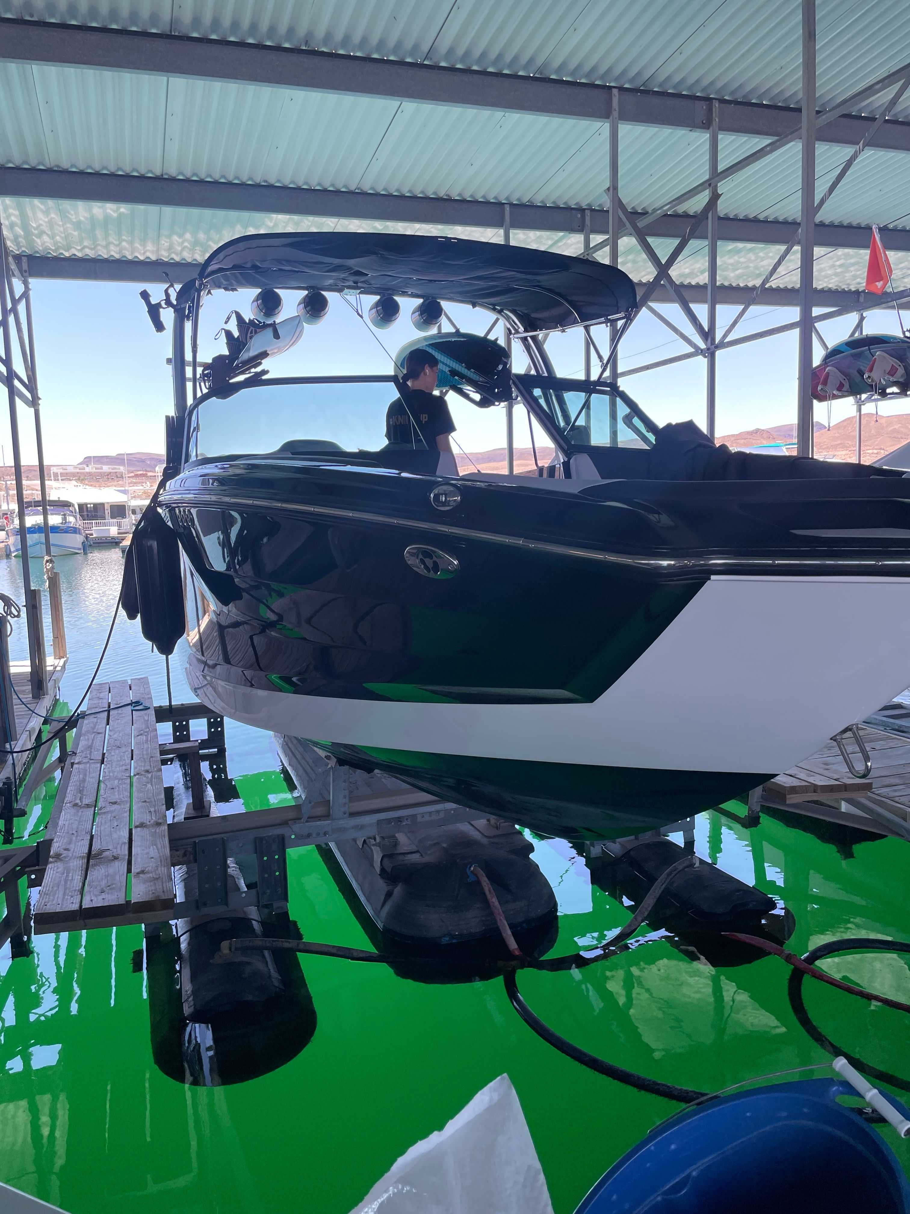 A MasterCraft NXT23 boat is in a covered dock.