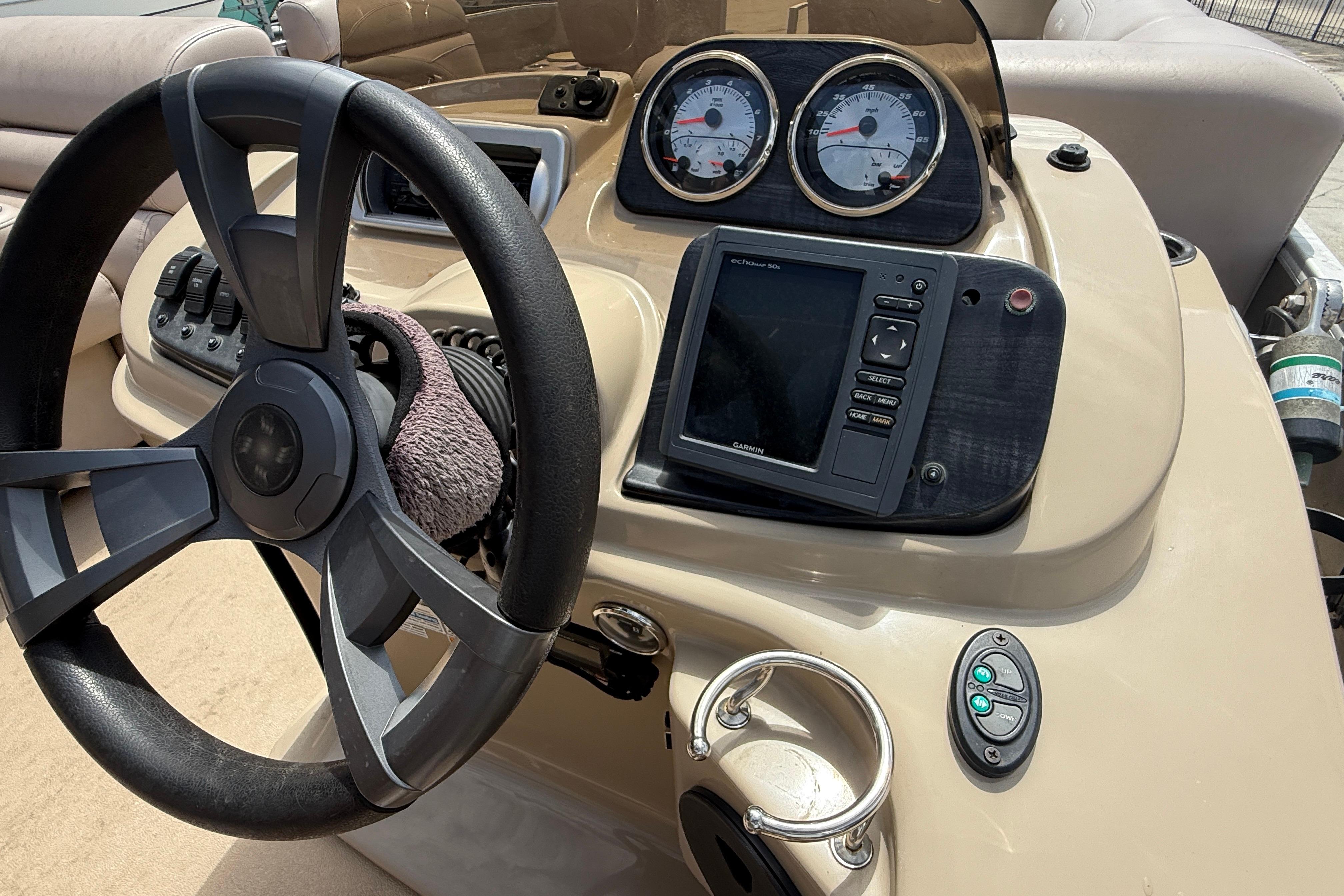 Steering console of 2014 Godfrey Sweetwater 2486 C boat with gauges and navigation system.