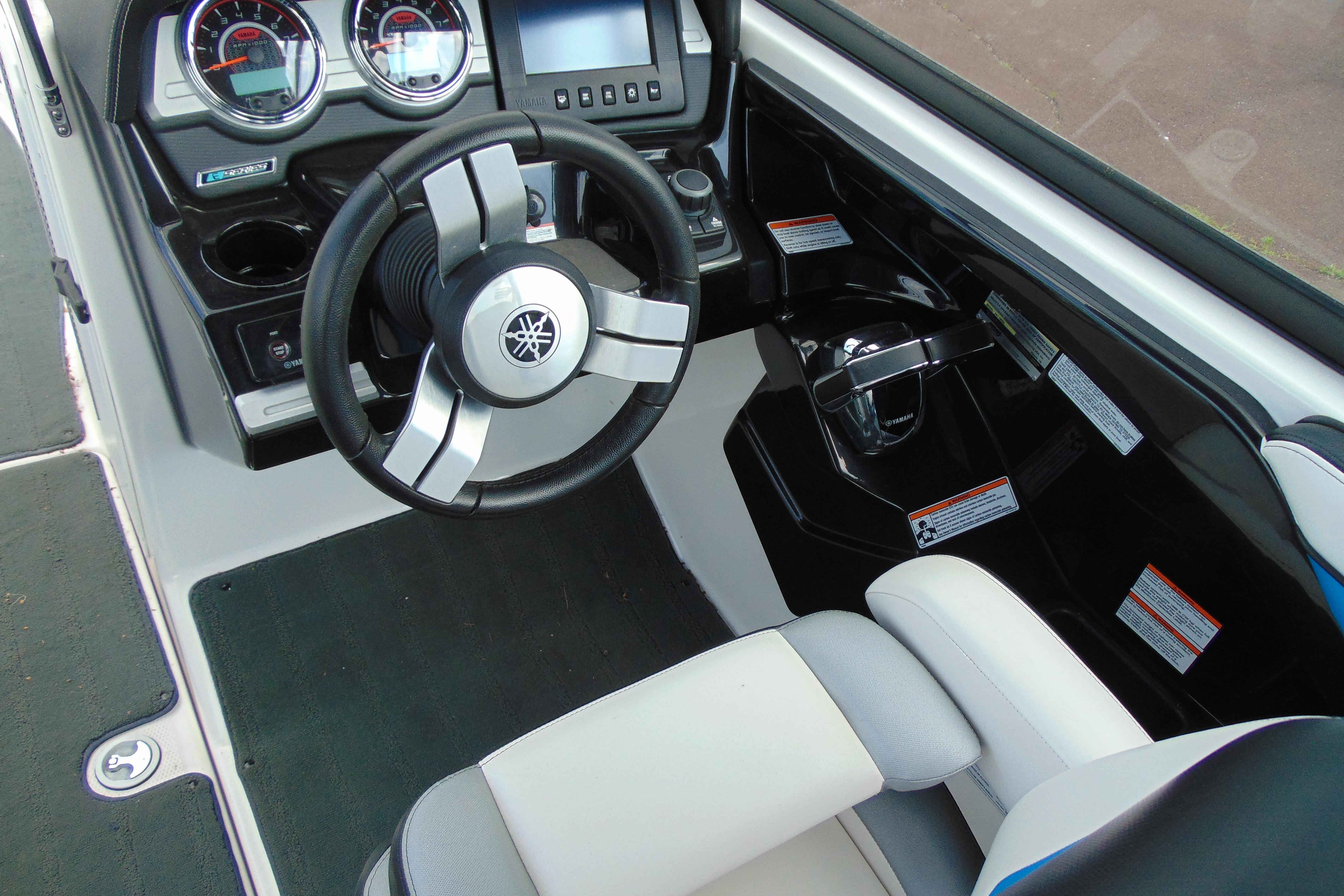 Interior cockpit of 2016 Yamaha Boats 242X E-Series, featuring steering wheel and dashboard controls.