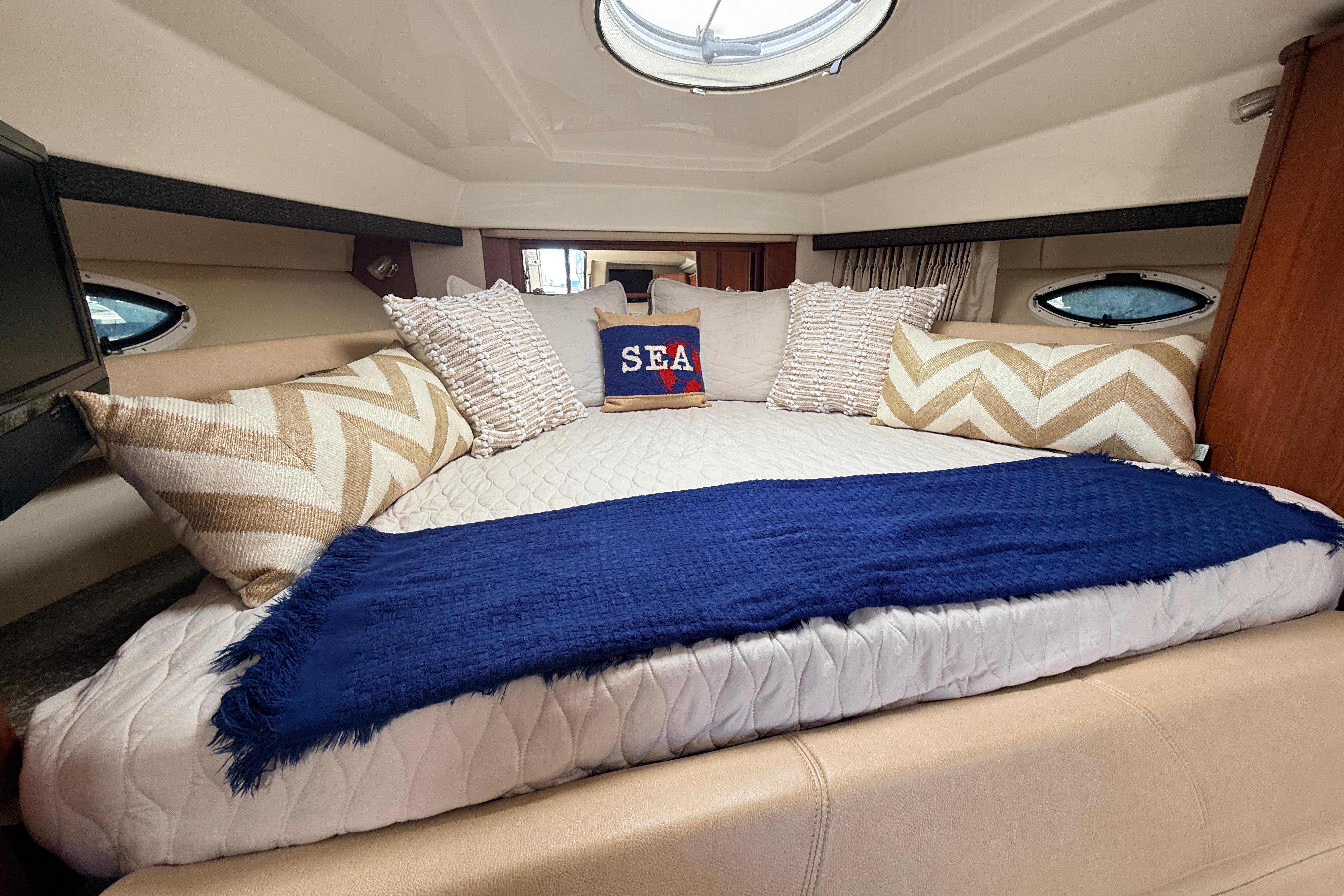 Luxurious cabin interior of 2011 Monterey 320 Sport Yacht with cozy bedding and nautical decor.