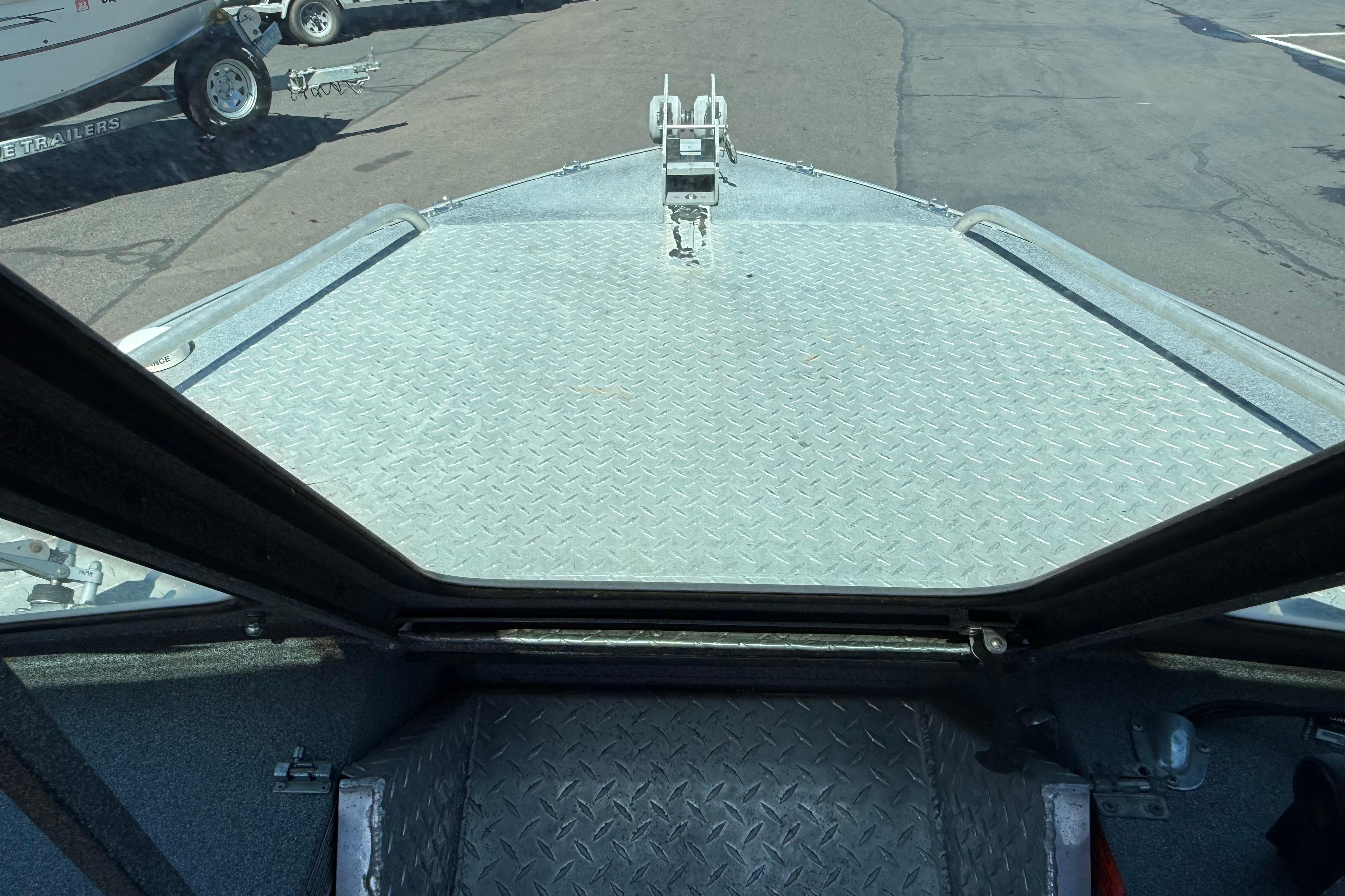 2004 Alumaweld Intruder Outboard 20 boat deck with diamond plate surface.