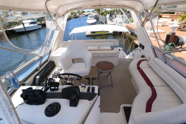 1992 Sea Ray 350 Express Bridge interior with helm, seating, and waterfront view.
