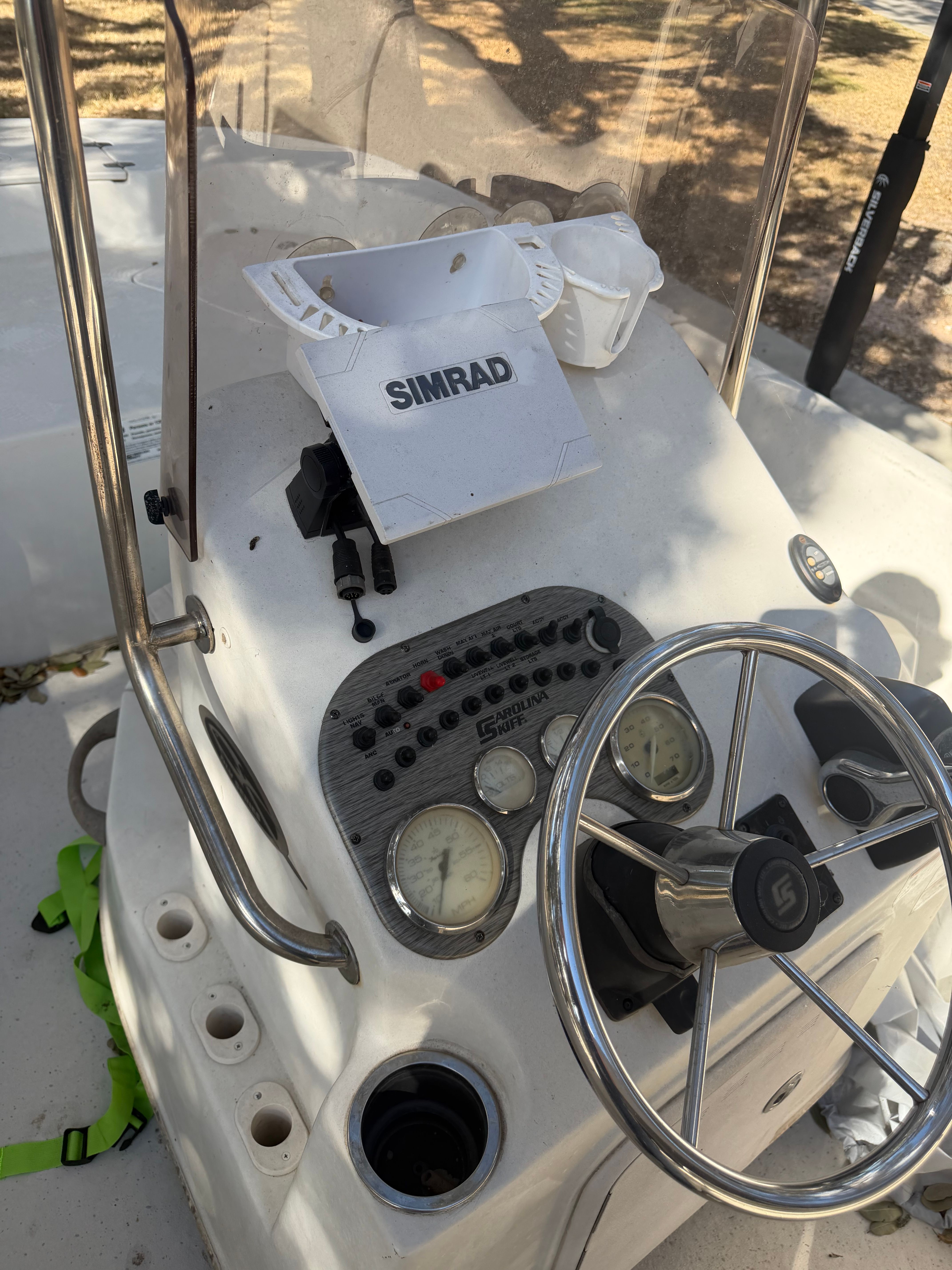 The image shows a boat's helm with a steering wheel and instruments.