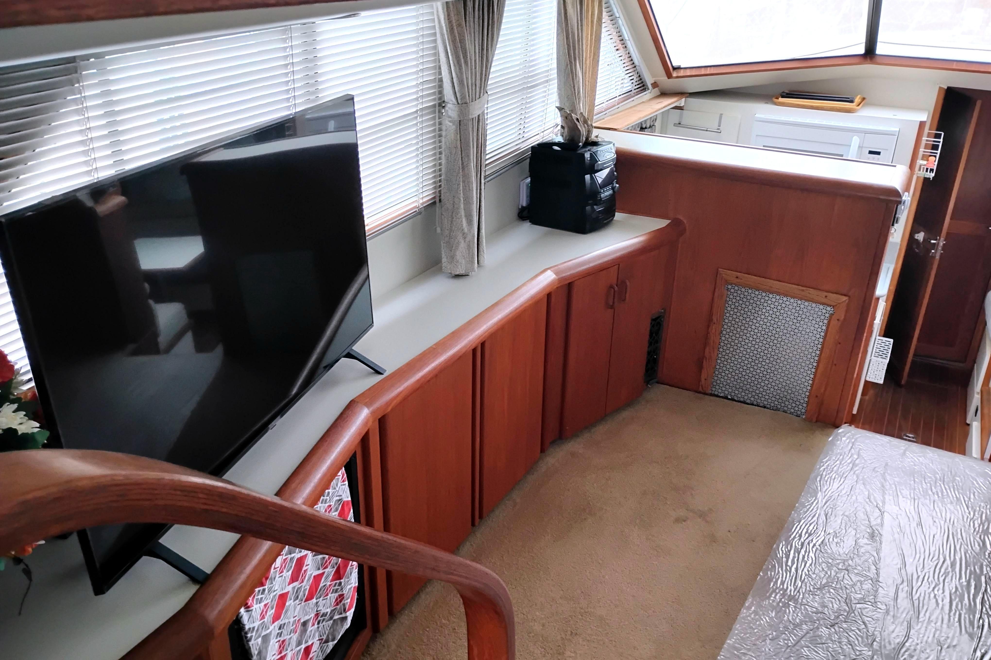 Interior of 1991 Californian 52 Cockpit Motor Yacht with TV and wooden cabinetry.