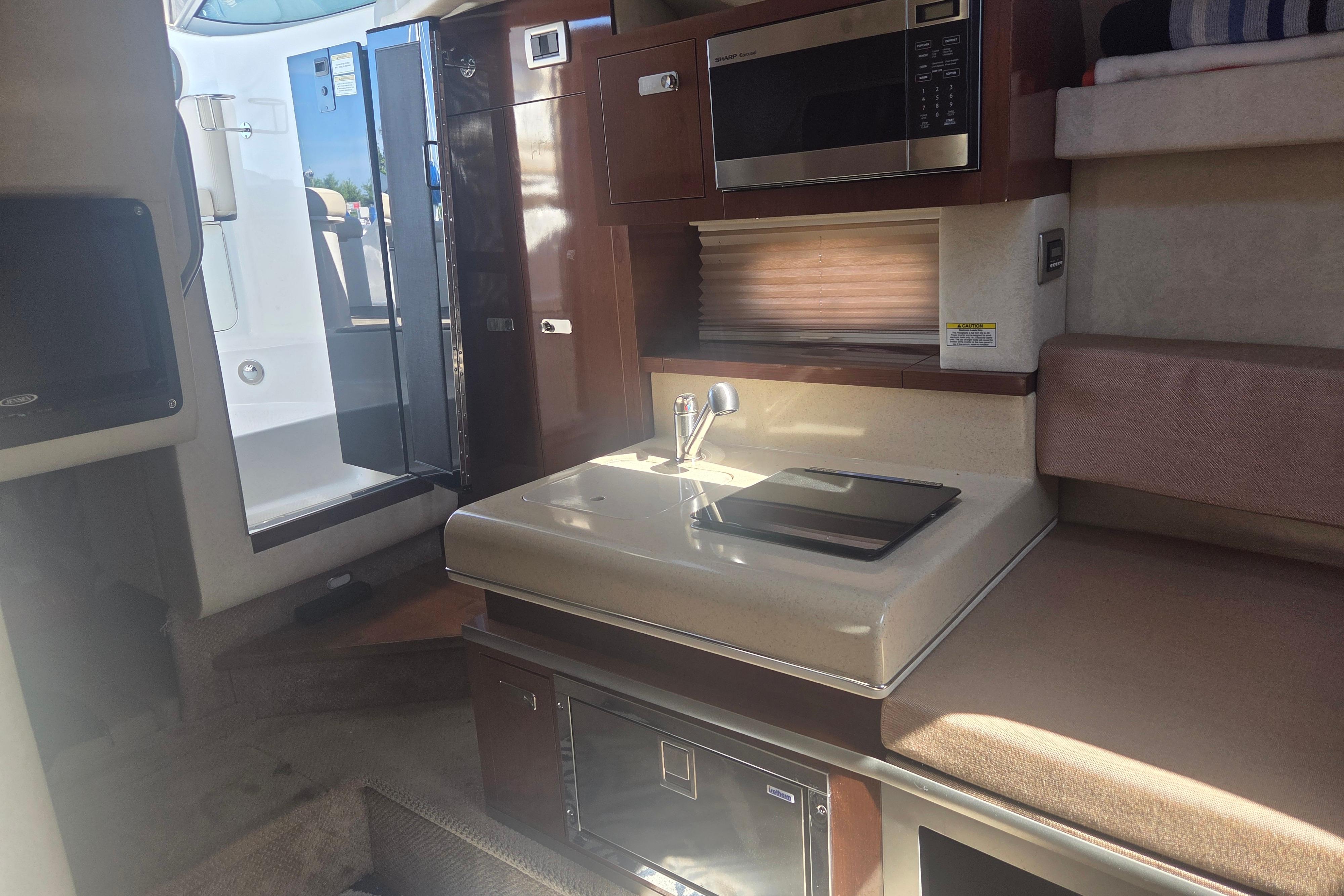Interior of a 2012 Sea Ray Sundancer 260 boat, featuring a compact kitchenette.