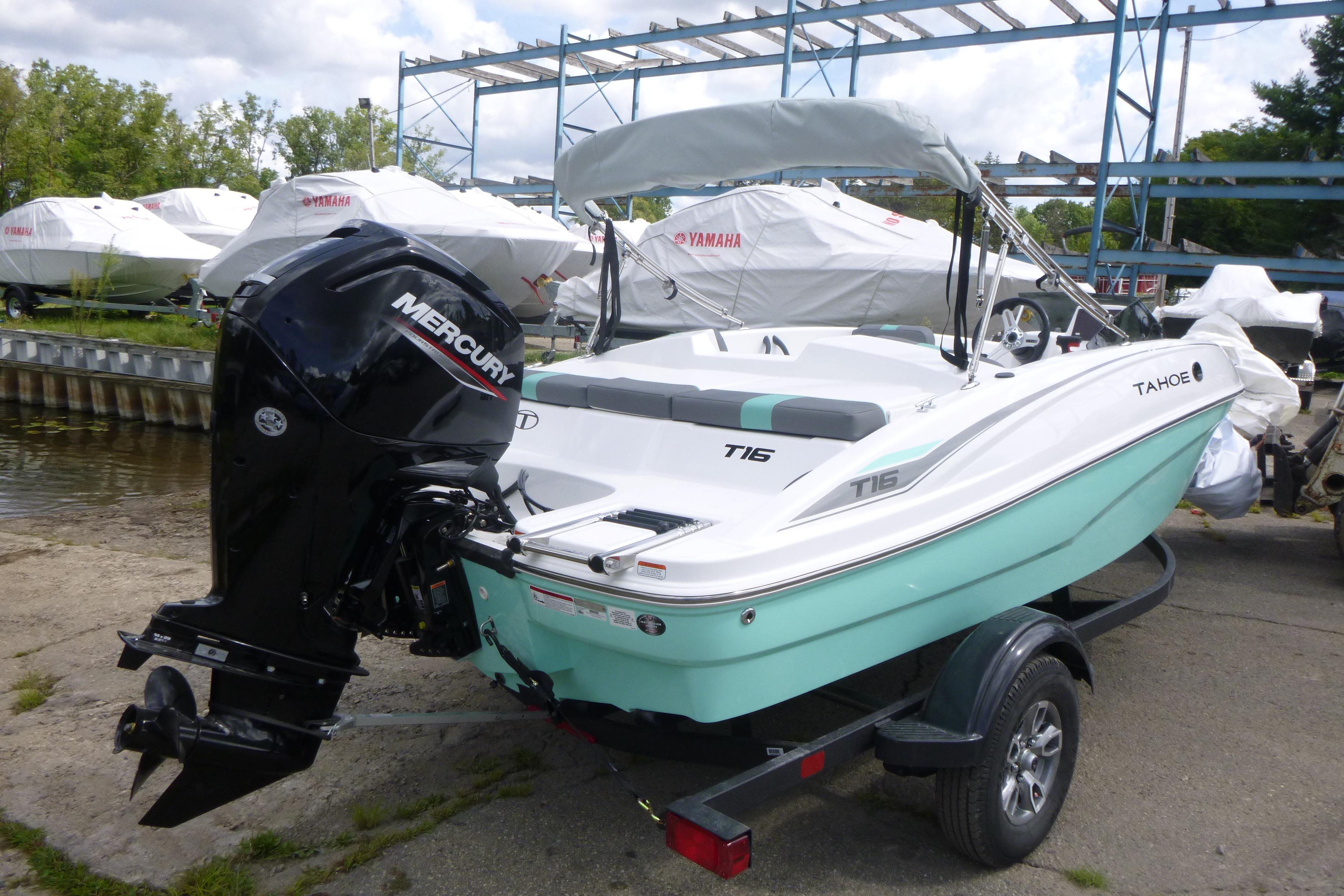 2026 Tahoe T16 boat with Mercury engine on trailer, parked near water.