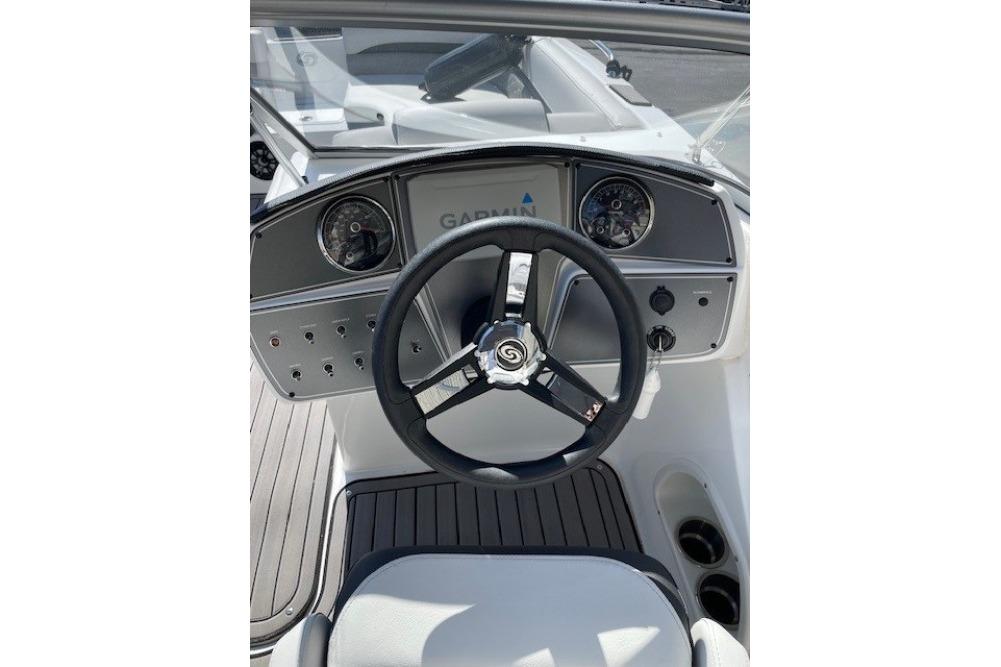2023 Hurricane SunDeck 217 OB boat dashboard with steering wheel and Garmin display.