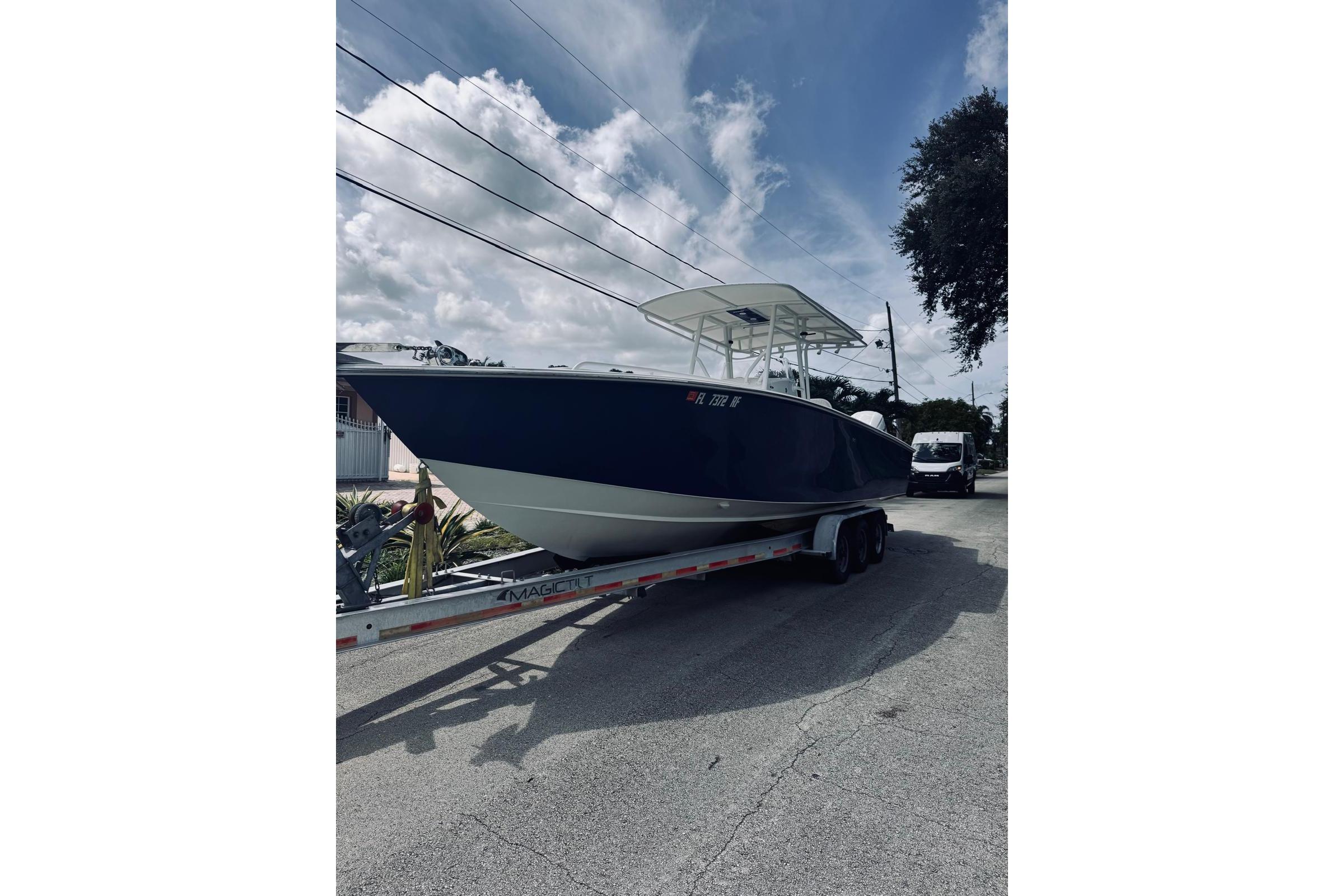 2005 Jupiter 31 boat on trailer under cloudy sky.