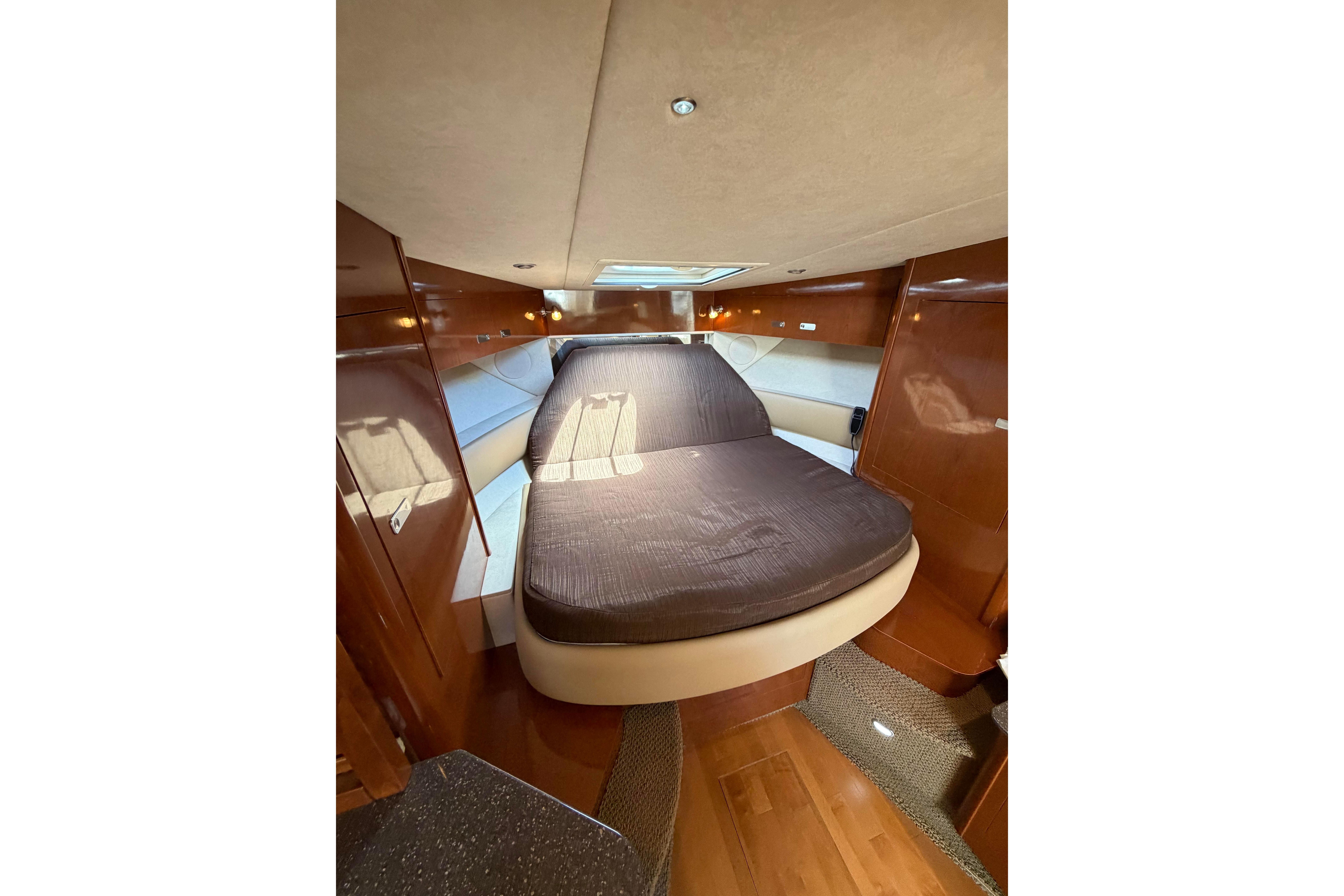 Luxurious cabin interior of 2012 Sea Ray Sundancer 370 yacht with cozy bed.
