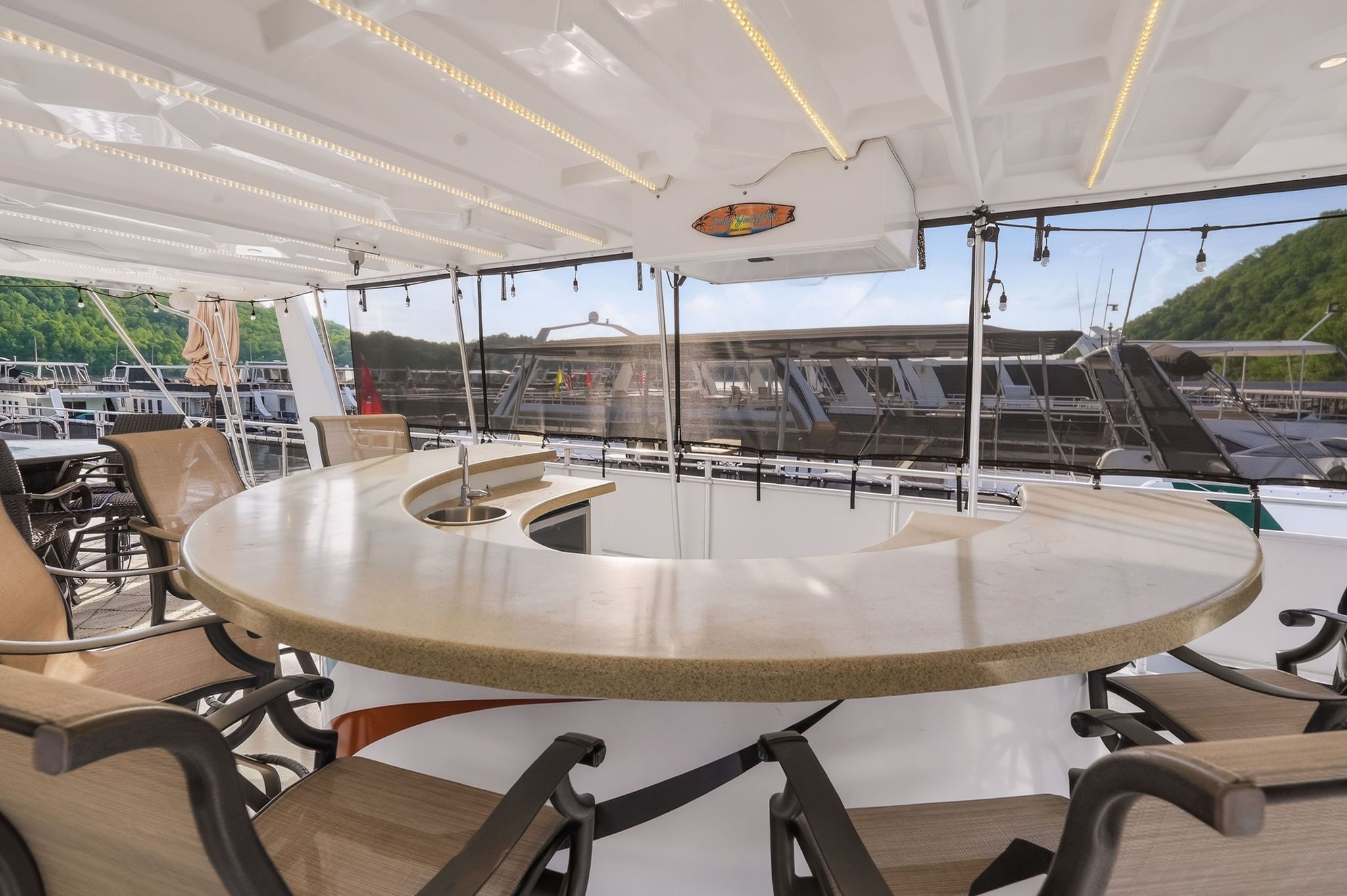 Luxurious houseboat interior with round bar and panoramic view.