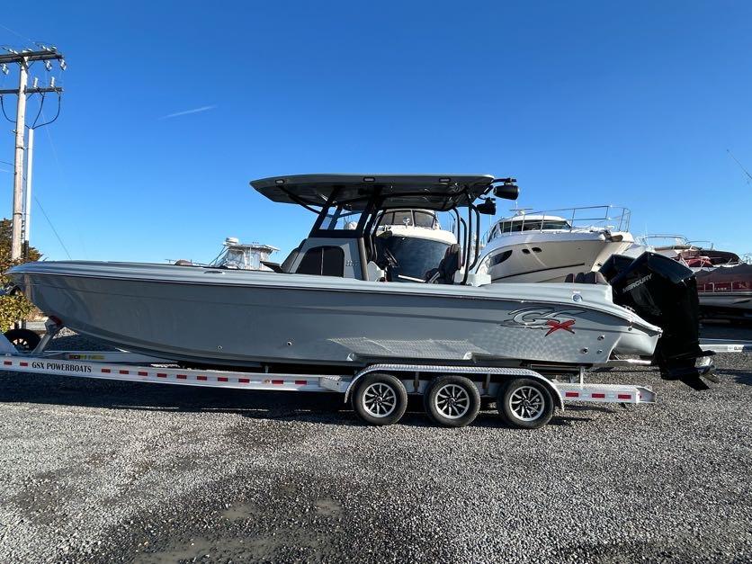 2024 Glasstream 32 GSX boat on trailer, parked outdoors under clear blue sky.