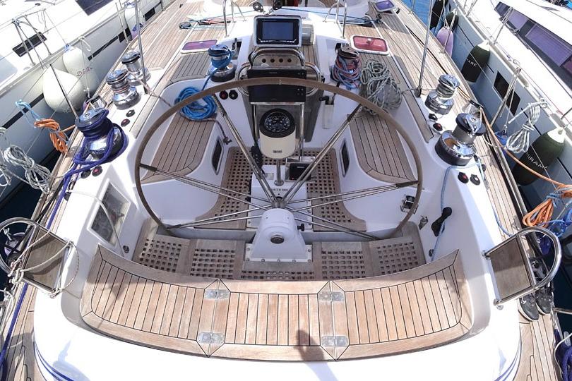 Cockpit of a 2001 Farr 65 yacht with wooden deck and steering wheel.