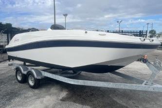 2021 Hurricane SunDeck Sport 192 RL OB boat on trailer, parked outdoors.